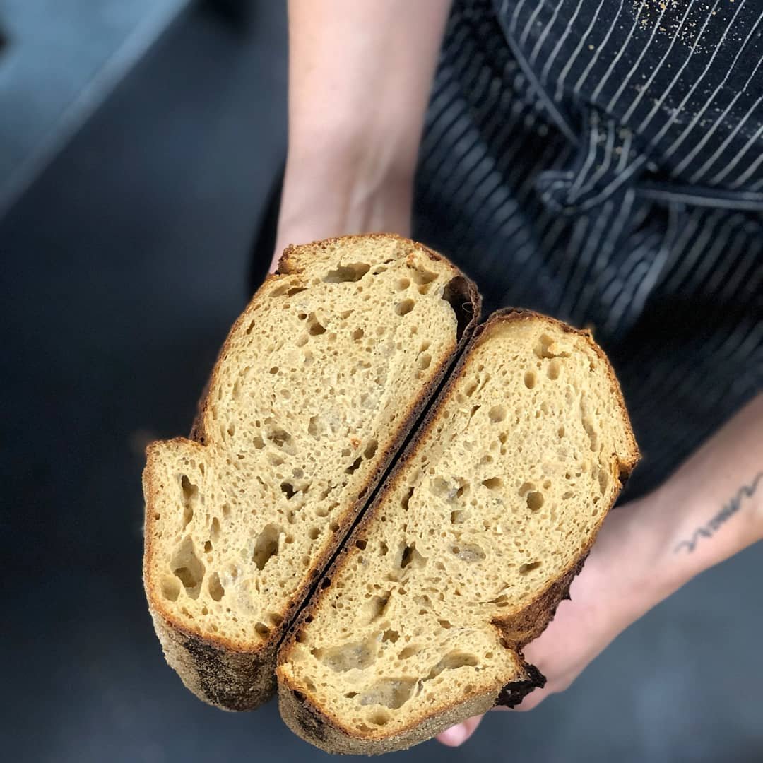 Chef holding fresh sliced wheat bread at SRV Boston.