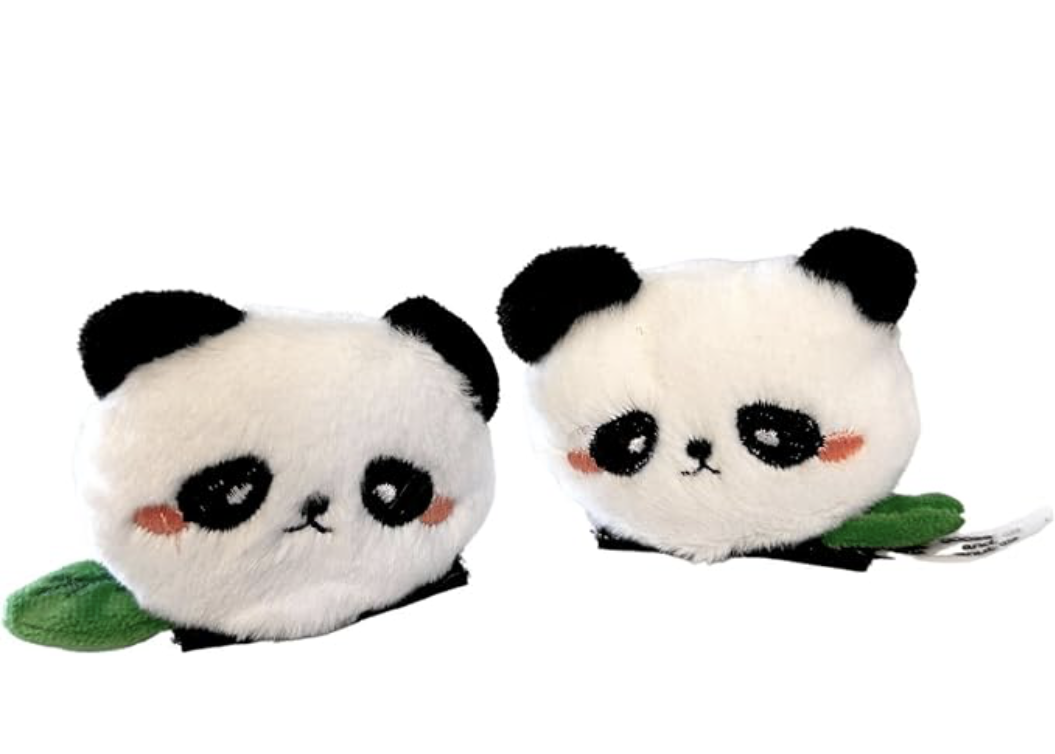 Two plush panda toys with round white faces, black ears, and black eyes with red blush marks, each holding a green leaf.