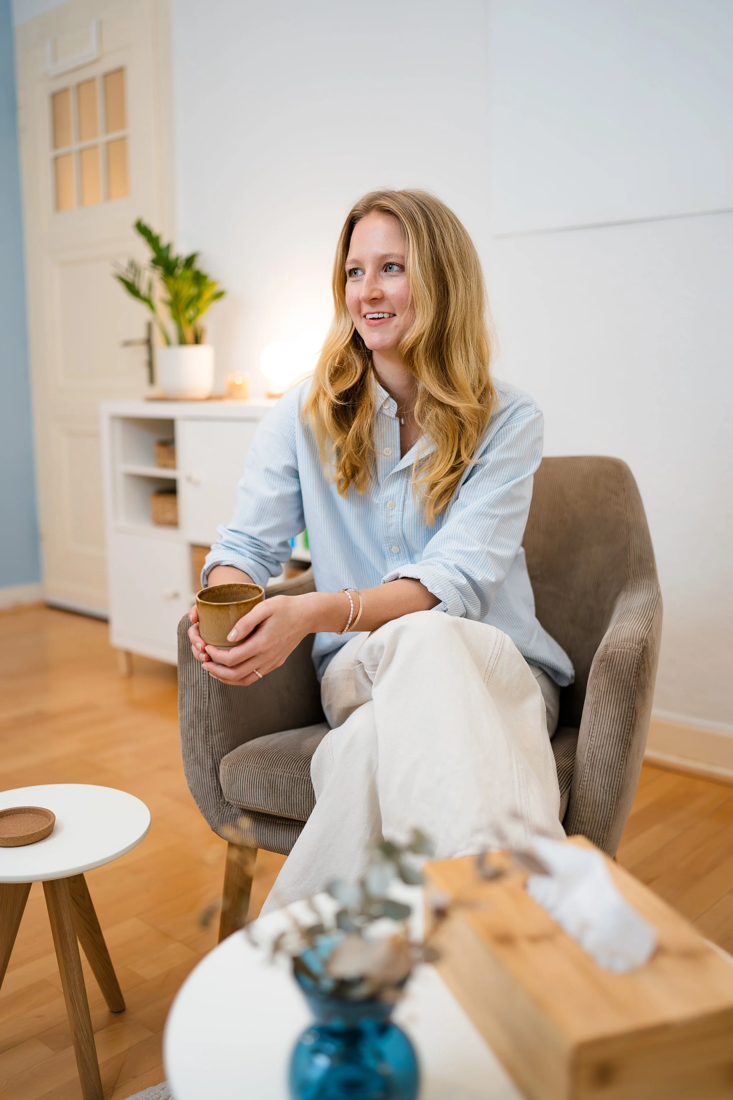 Zu sehen ist eine Psychologin und Paartherapeutin, die auf einem Stuhl sitzt in Ihrer Praxis für Paartherapie in Düsseldorf.