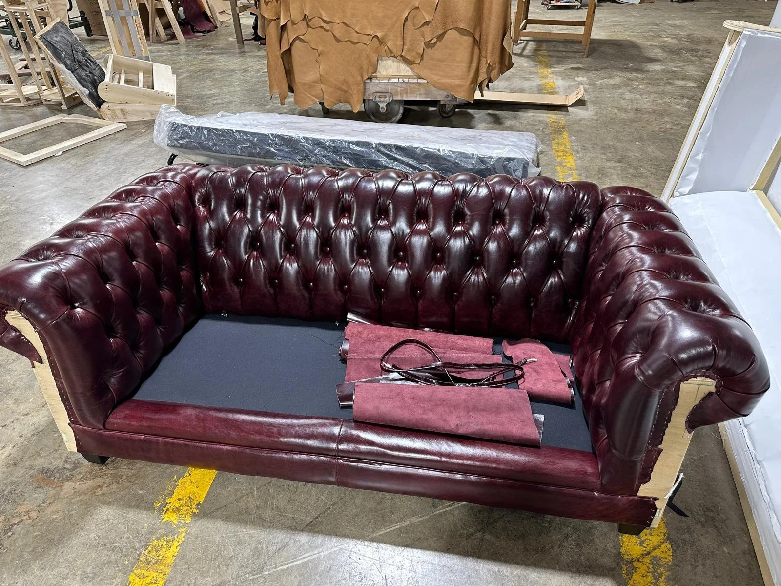 Custom Chesterfield sofa in production at Patrona Studio workshop showing hand-tufted leather upholstery craftsmanship