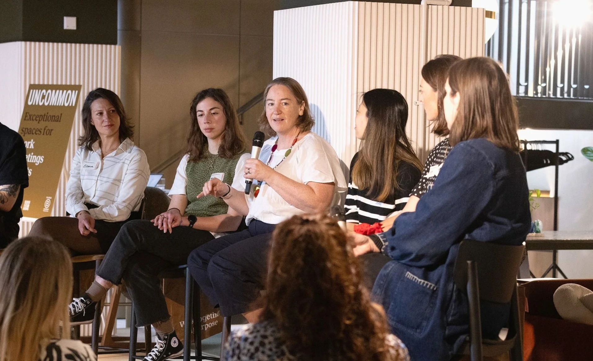 Sally Prtichett participating in a B Corp Month panel discussion, holding a microphone and speaking about communications and culture, while others listen attentively.