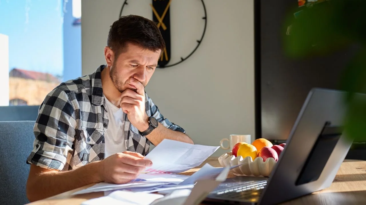 Man reviewing a collection notice while researching LVNV Funding LLC lawsuits and credit report issues