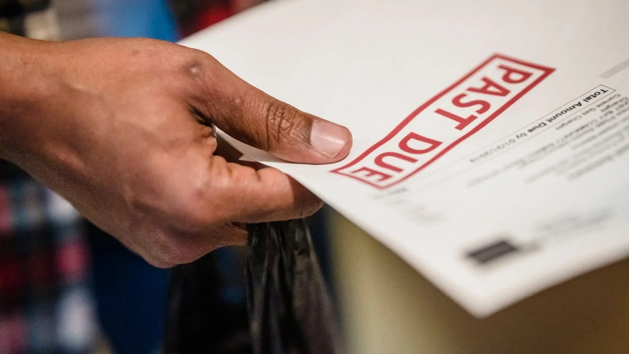 Hand holding a debt collection letter suggesting a past due balance