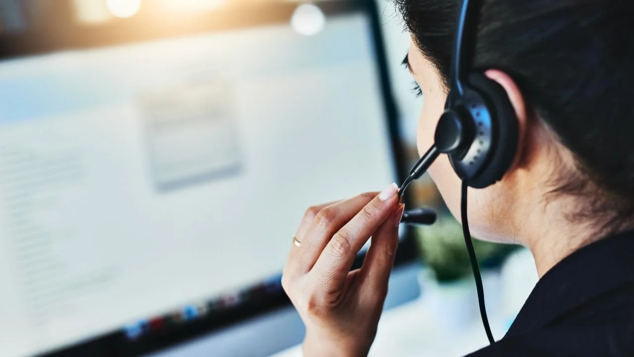 Call center agent with headset speaking on the phone, representing debt collector number 866-451-1216.