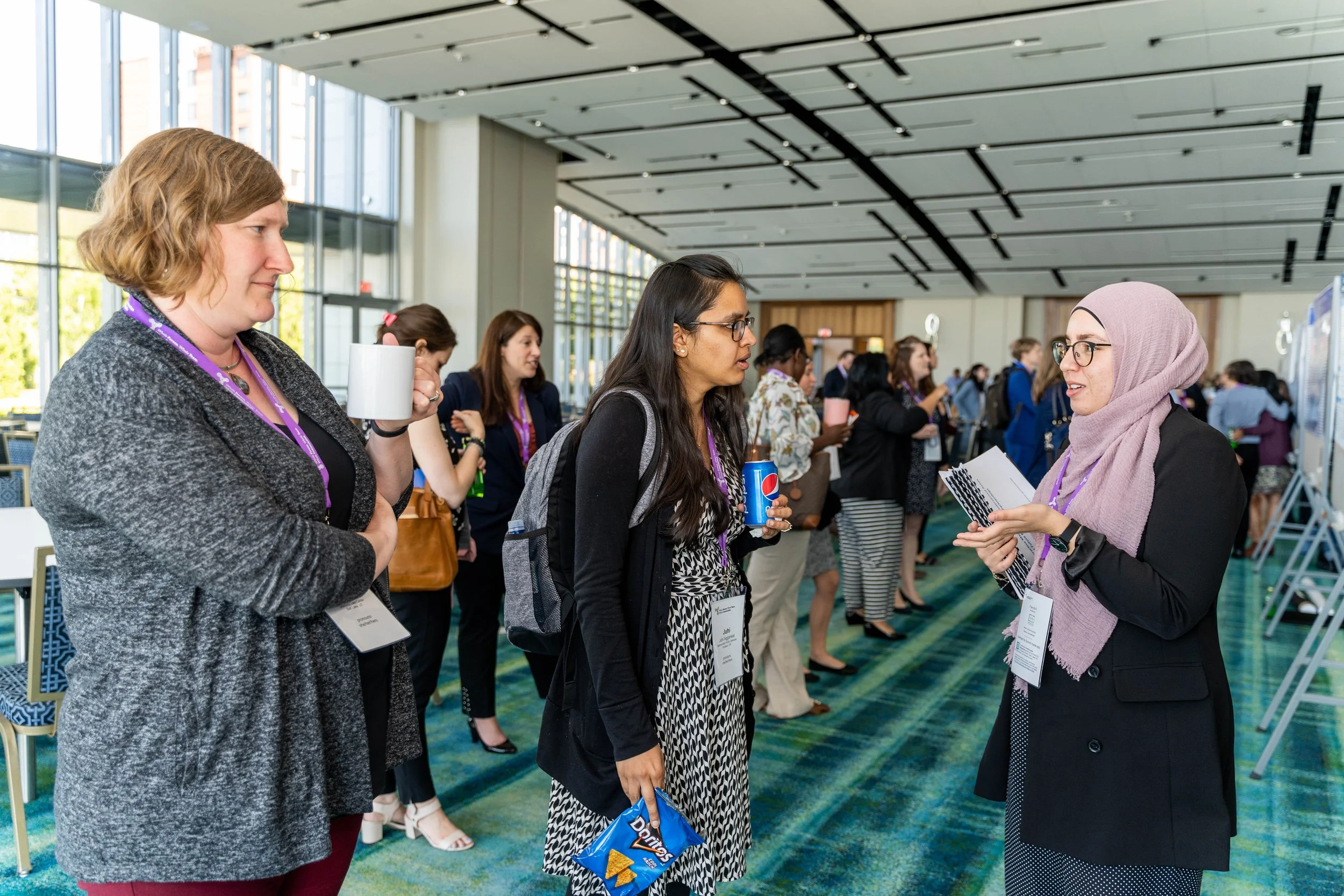  Attendees discussing research posters at the 2019 MLP Summit. 