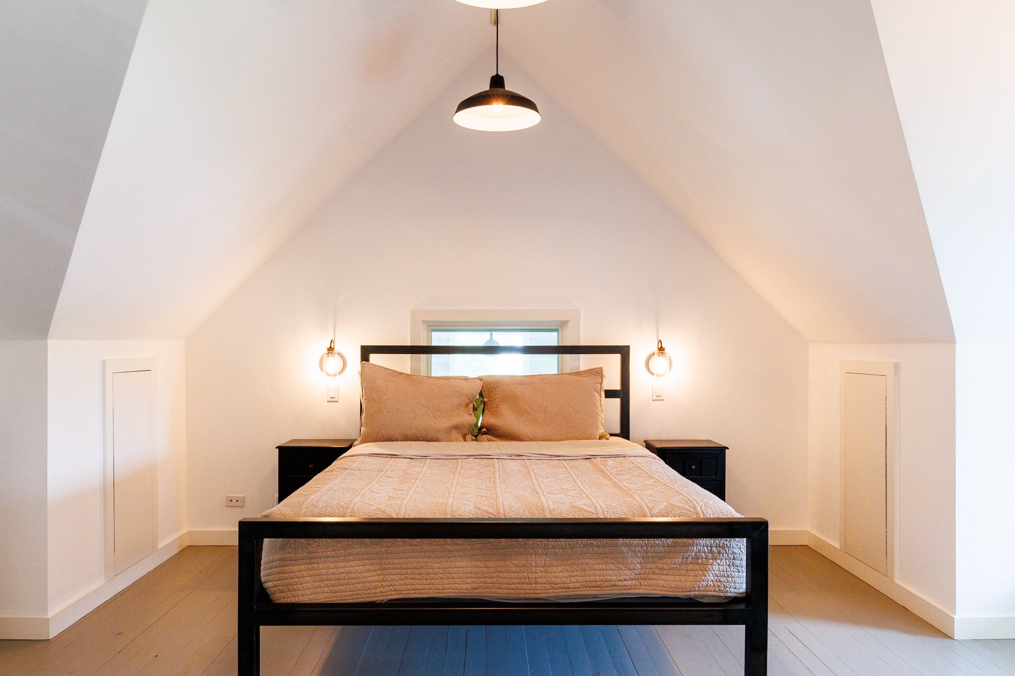 Stunning interior real estate photography of a bedroom.  This room features a geometric architecture, soft lighting, and an ambience that notes peace