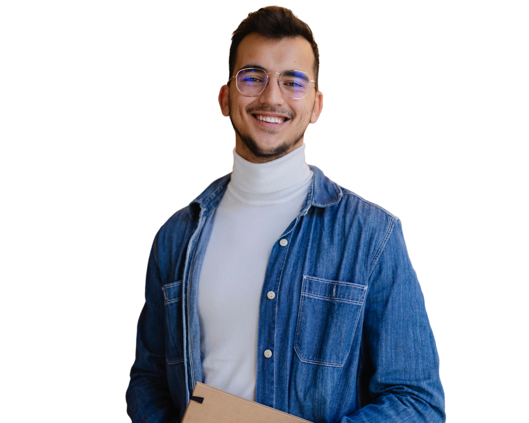 Young man smiling, wearing glasses, a white turtleneck, and a denim shirt, holding a cardboard box.