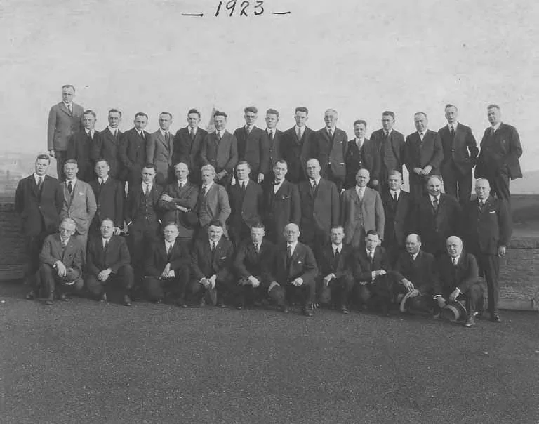 Vintage photograph of corporate office workers 1920s, representing the era when pensions first created long-term employee retention strategies.