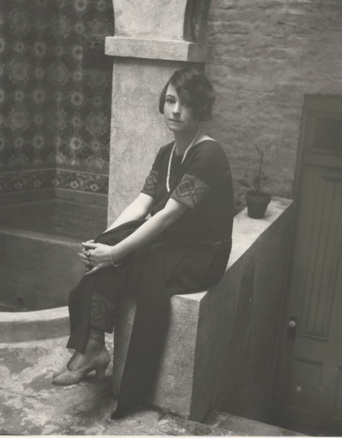 Dorothy Parker in backyard of residence at 412 West 47th Street, New York City.