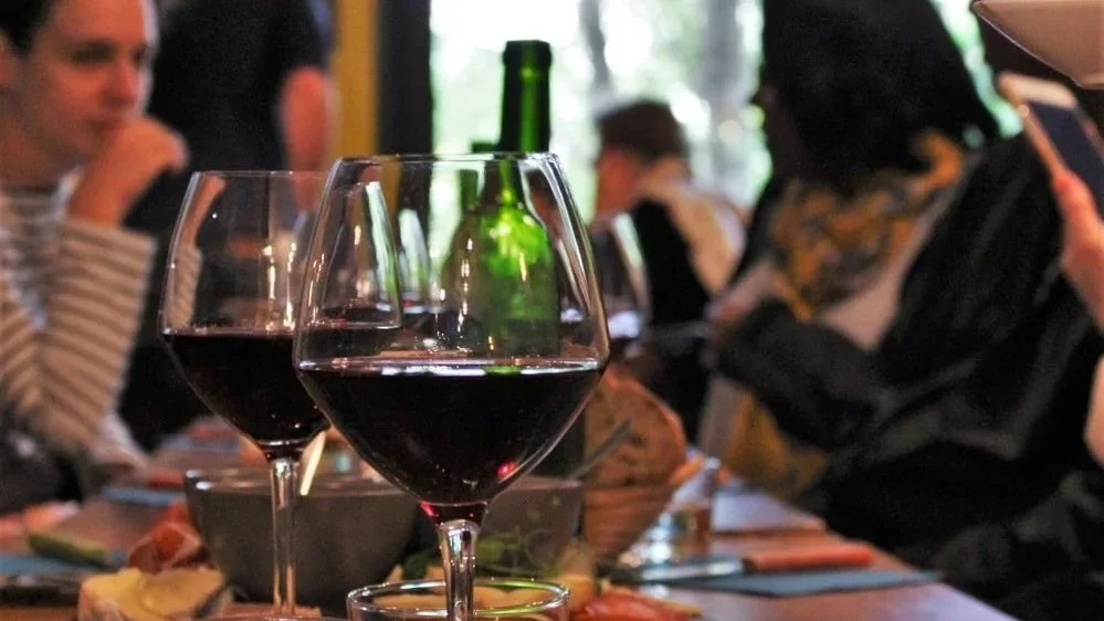 people sitting tasting wine on paris food tour