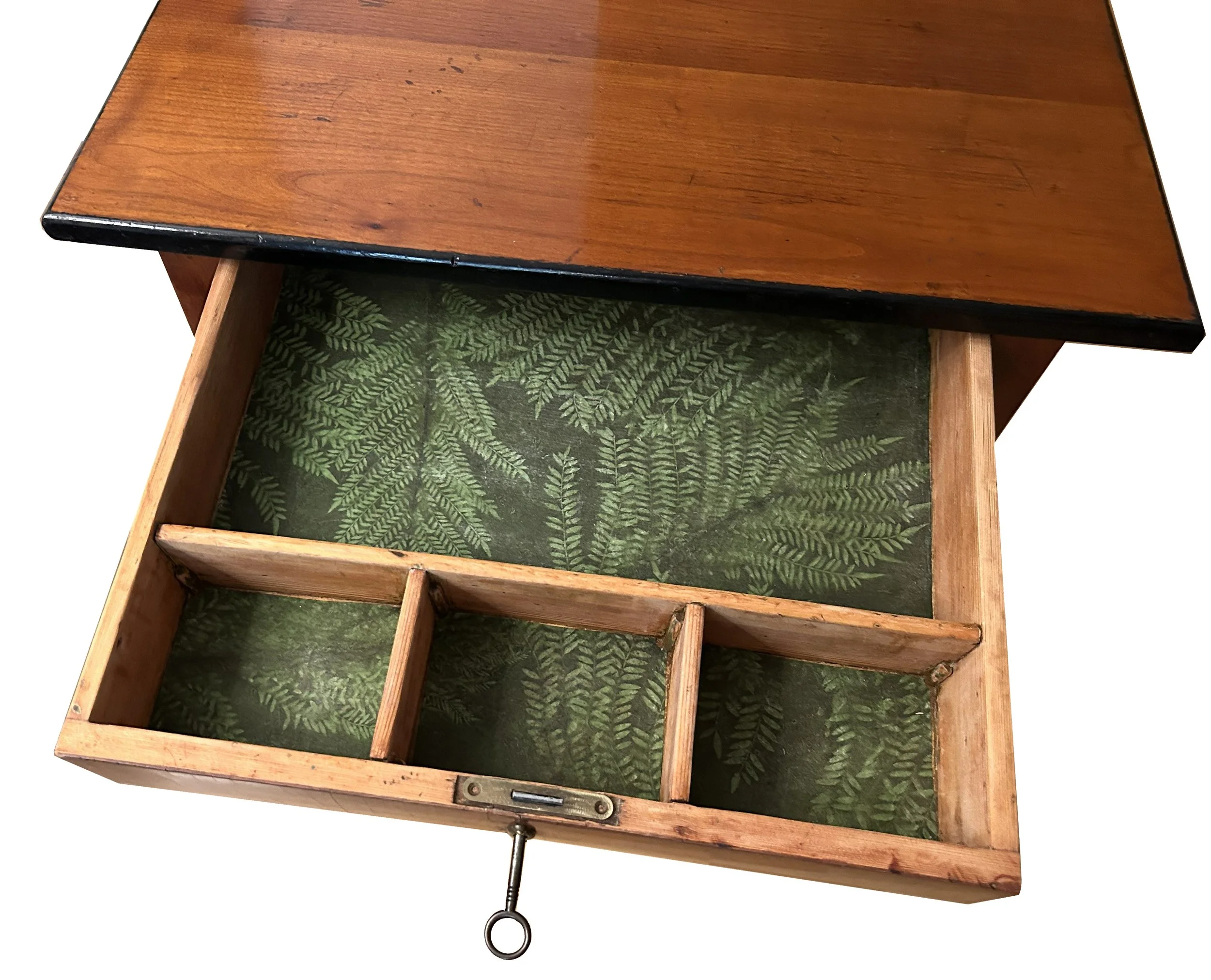 Detailaufnahme der Schubladeninnenseite eines restaurierten Nähtischchens mit Büttenpapier in Pflanzenoptik