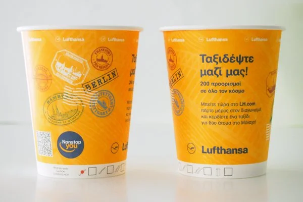 two disposable orange cups branded with a Lufthansa AD-cup campaign