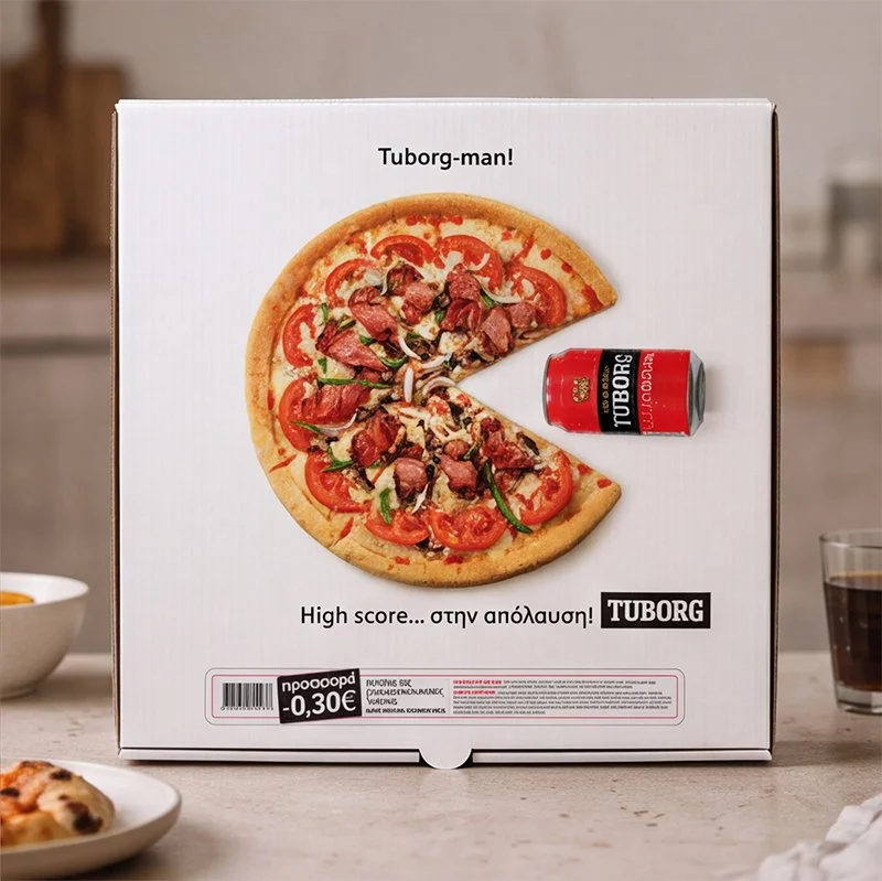 Box featuring an image of a pizza with pepperoni, tomatoes, and green peppers, a can of Tuborg beer, and Greek text, with a white background and kitchen setting.