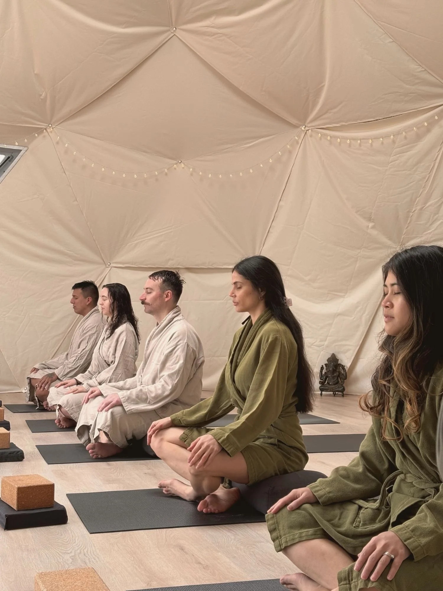 People in robes meditating in the Dome at Saltair during a Rise & Shine class