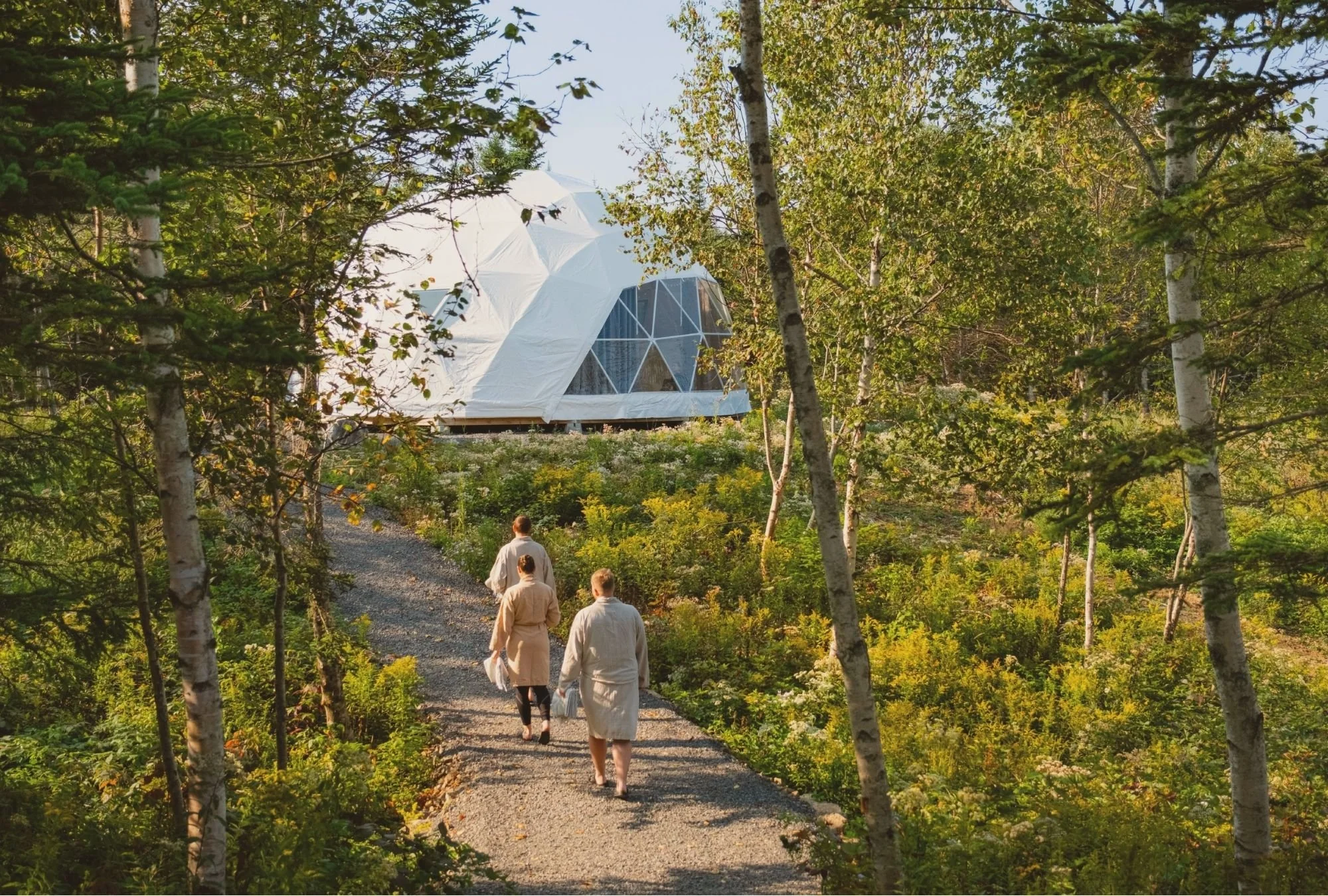 People wearing robes walking toward the yoga Dome at Saltair