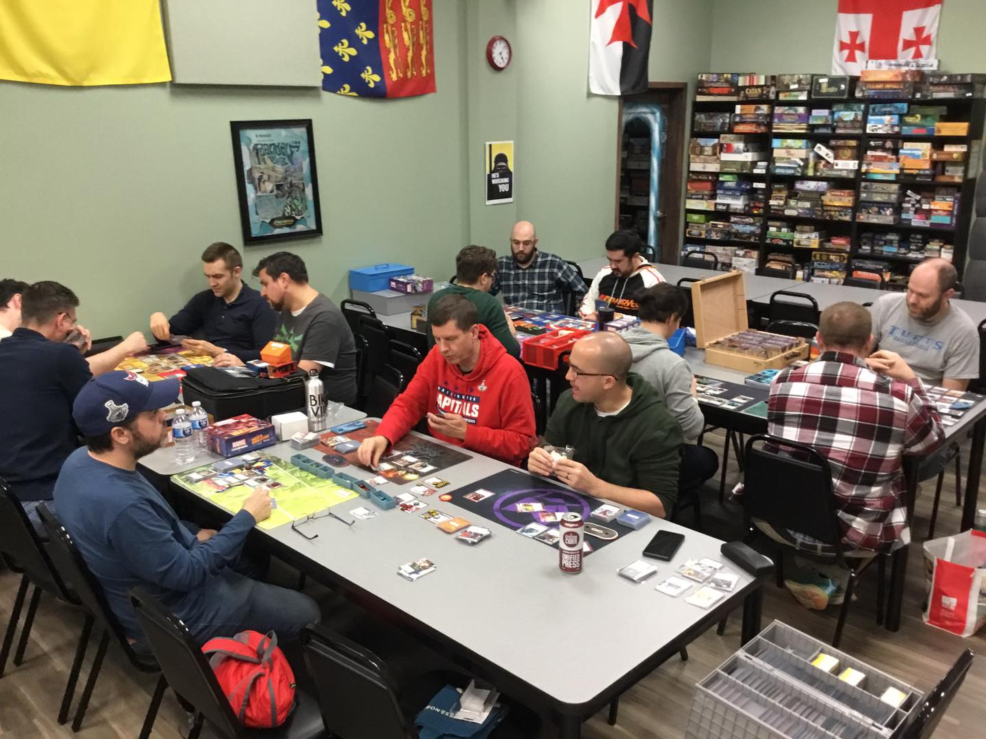 A group of people playing Marvel Champions Living Card Game at Huzzah Hobbies.