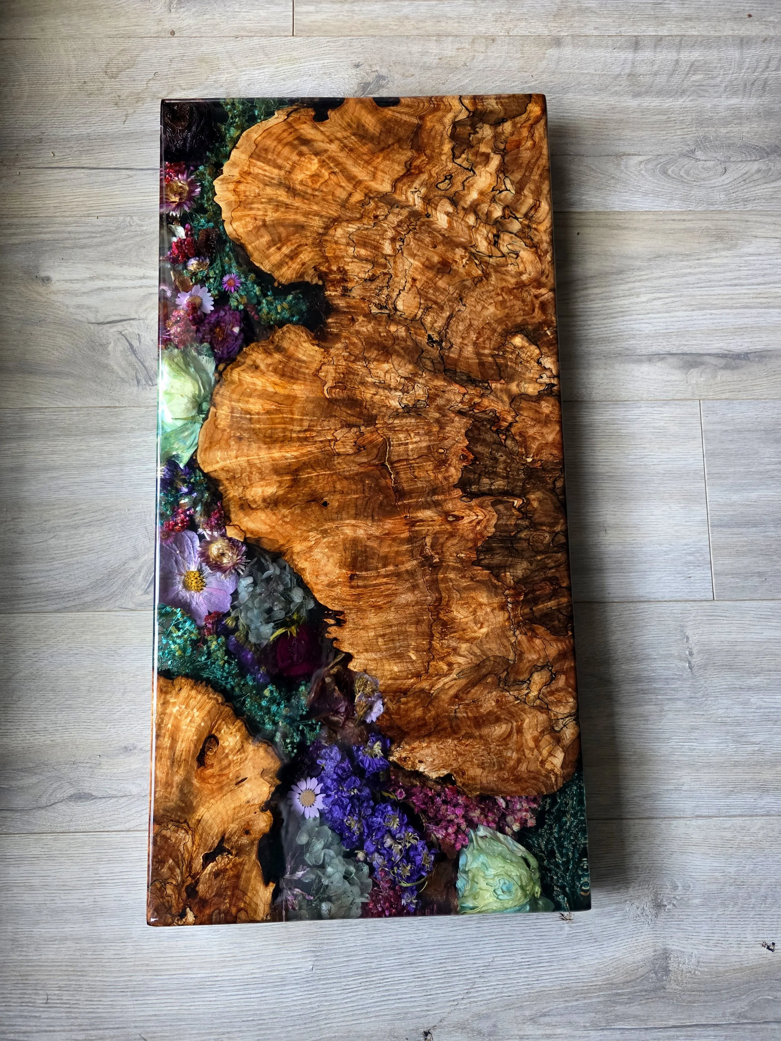 resin charcuterie board with dried flowers and live edge maple burl wood