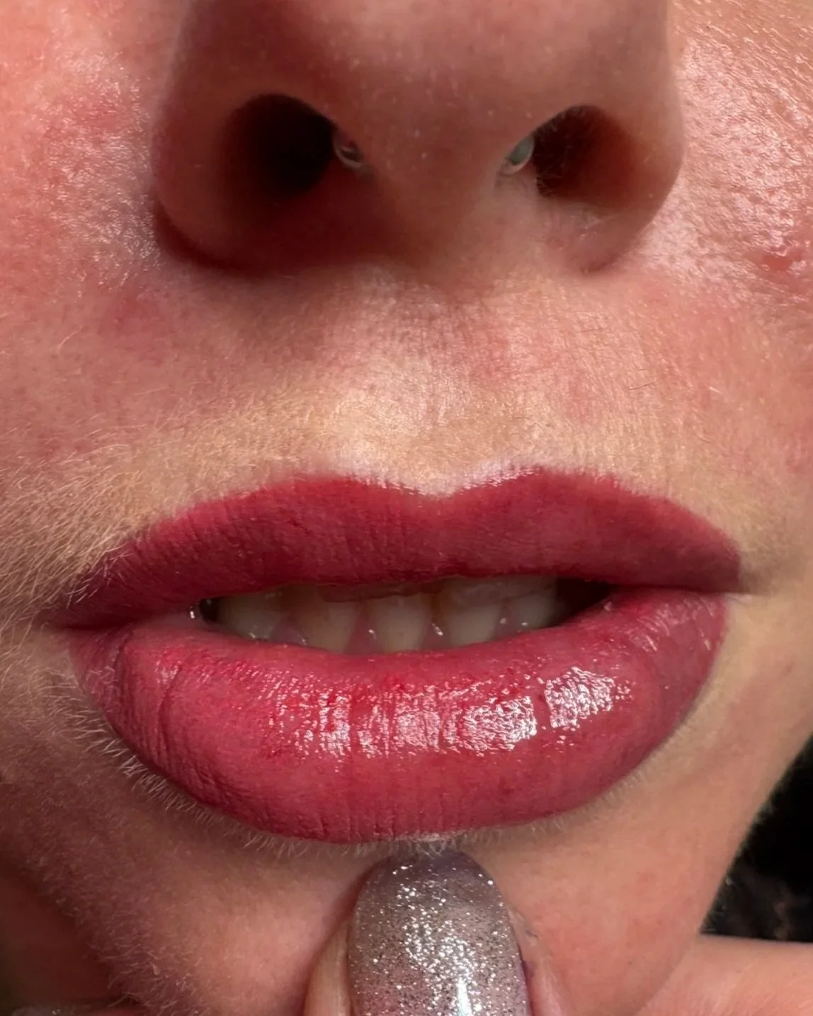 Nahaufnahme eines Lippenstifts mit einem menschlichen Mund und einer Nasenöffnung.