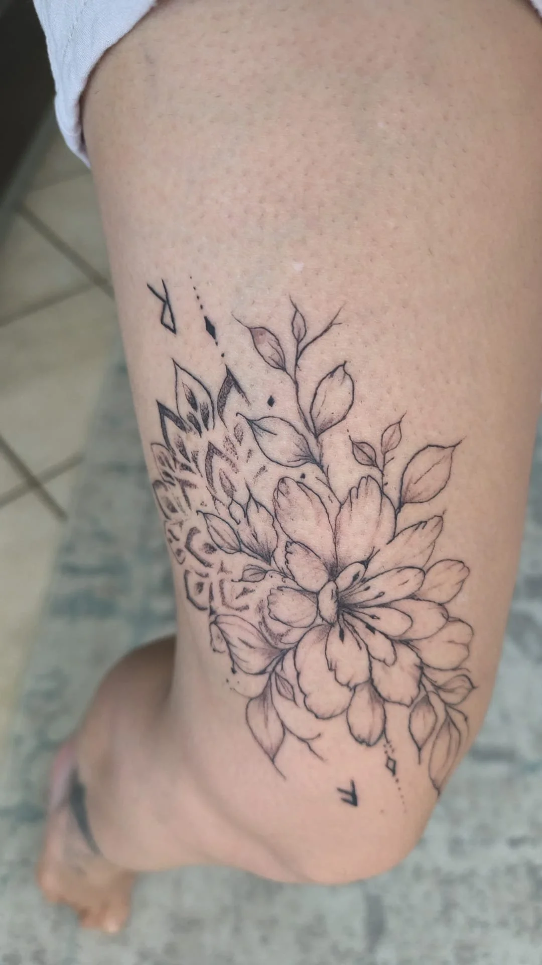 Detailaufnahme eines abgeheilten Fine Line Tattoos mit floralem Motiv und Mandala