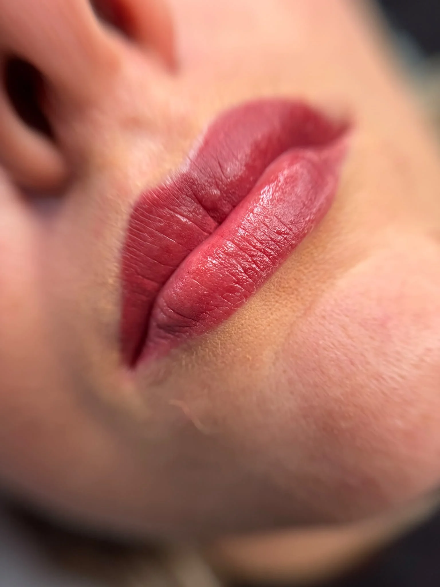 Nahaufnahme von roten Lippen, leicht geöffnet, mit sichtbarer Hautstruktur.