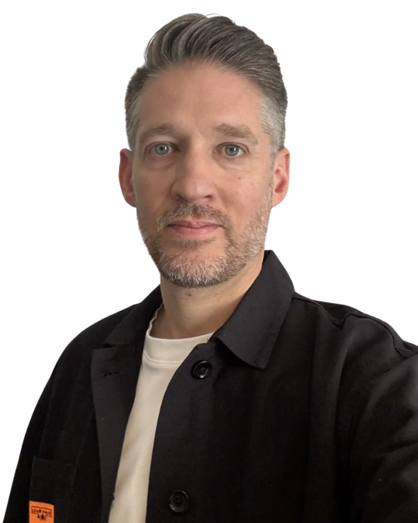 Image of a white man with brown hair looking at the camera. He has a beard and is wearing a white t-shirt with black Shacket