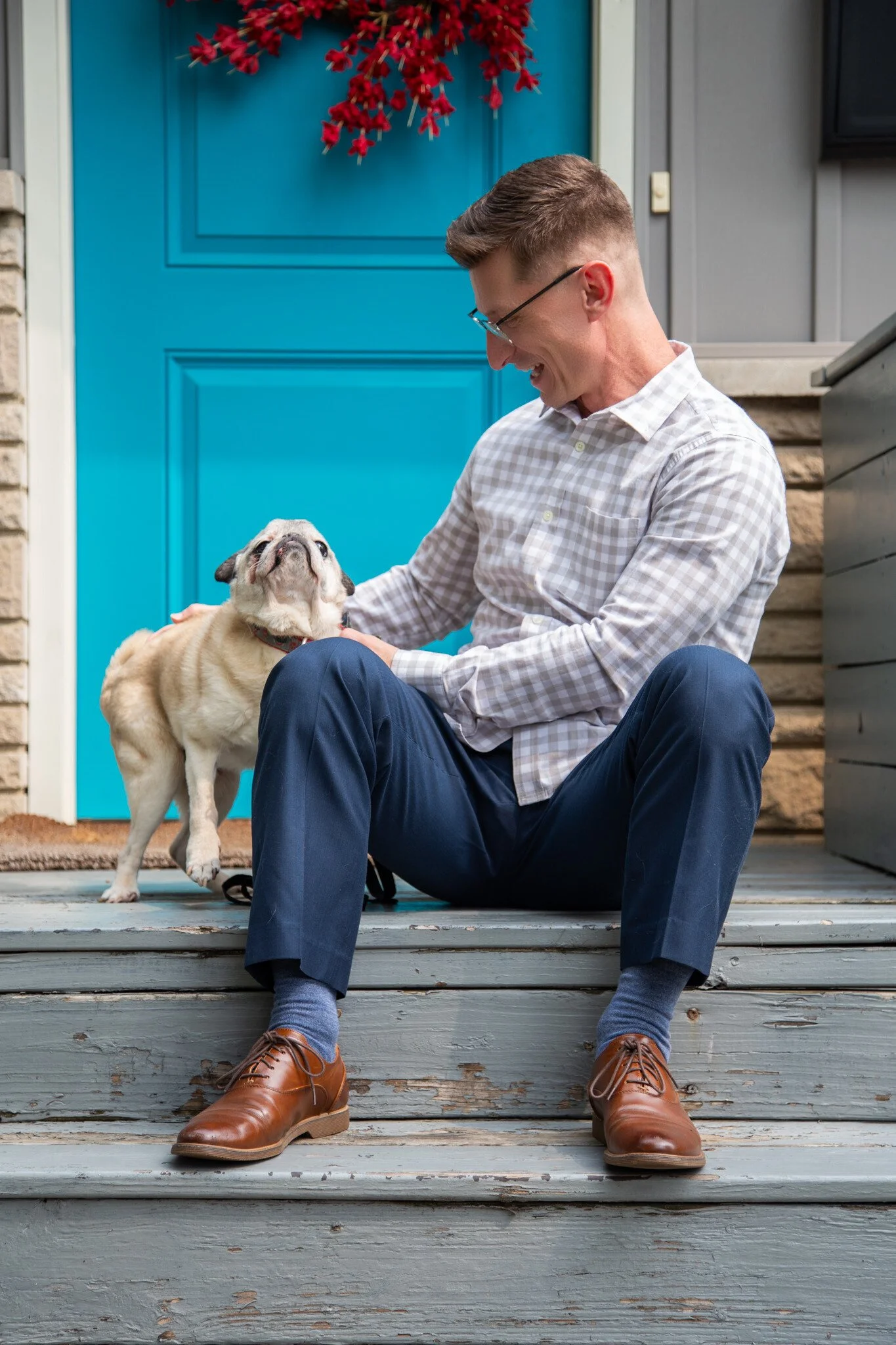 Dr. Danny G. petting and showing love to Mr. Cooper the (Peace & Belonging) Pug on the front porch of their home in Columbus, Ohio in Autumn 2025. Photo by Alec Cheravitch.