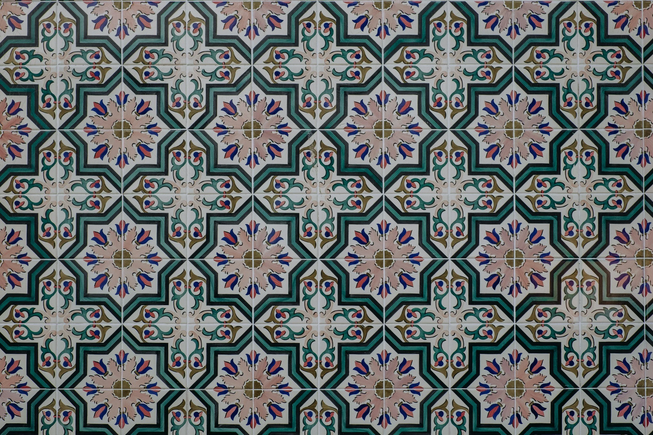Patterned ceramic tiles with intricate floral and geometric designs in blue, green, pink, and tan colors.