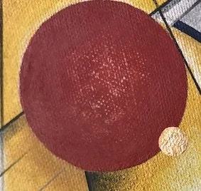 Red exercise ball on a gym floor with a small white object nearby.