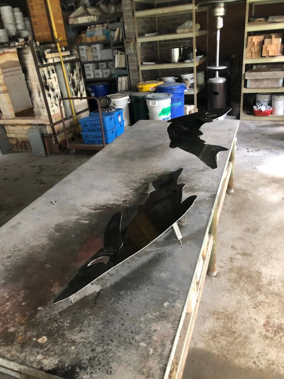 The pieces were already plasma cut for me- I just had to grind,  sand, prep and prime them for painting and paint them all. Here I am priming some of the salmon. 