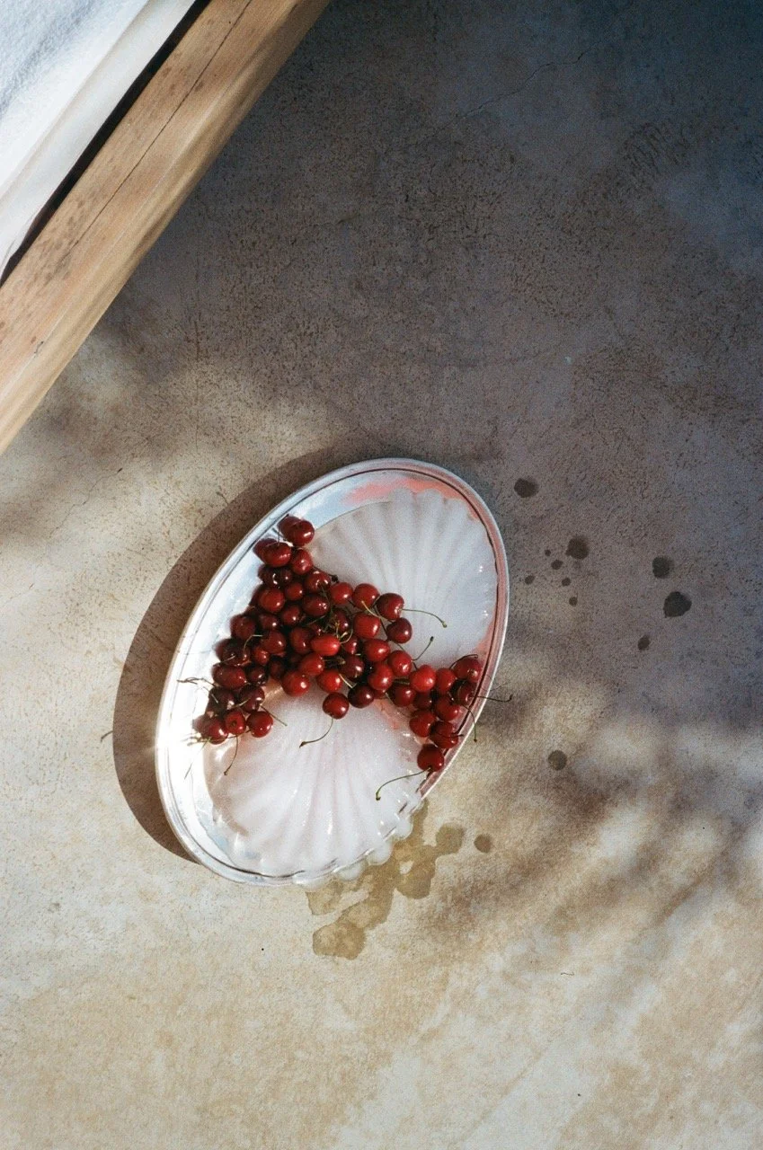 Red currants on a white ceramic dish on a concrete surface