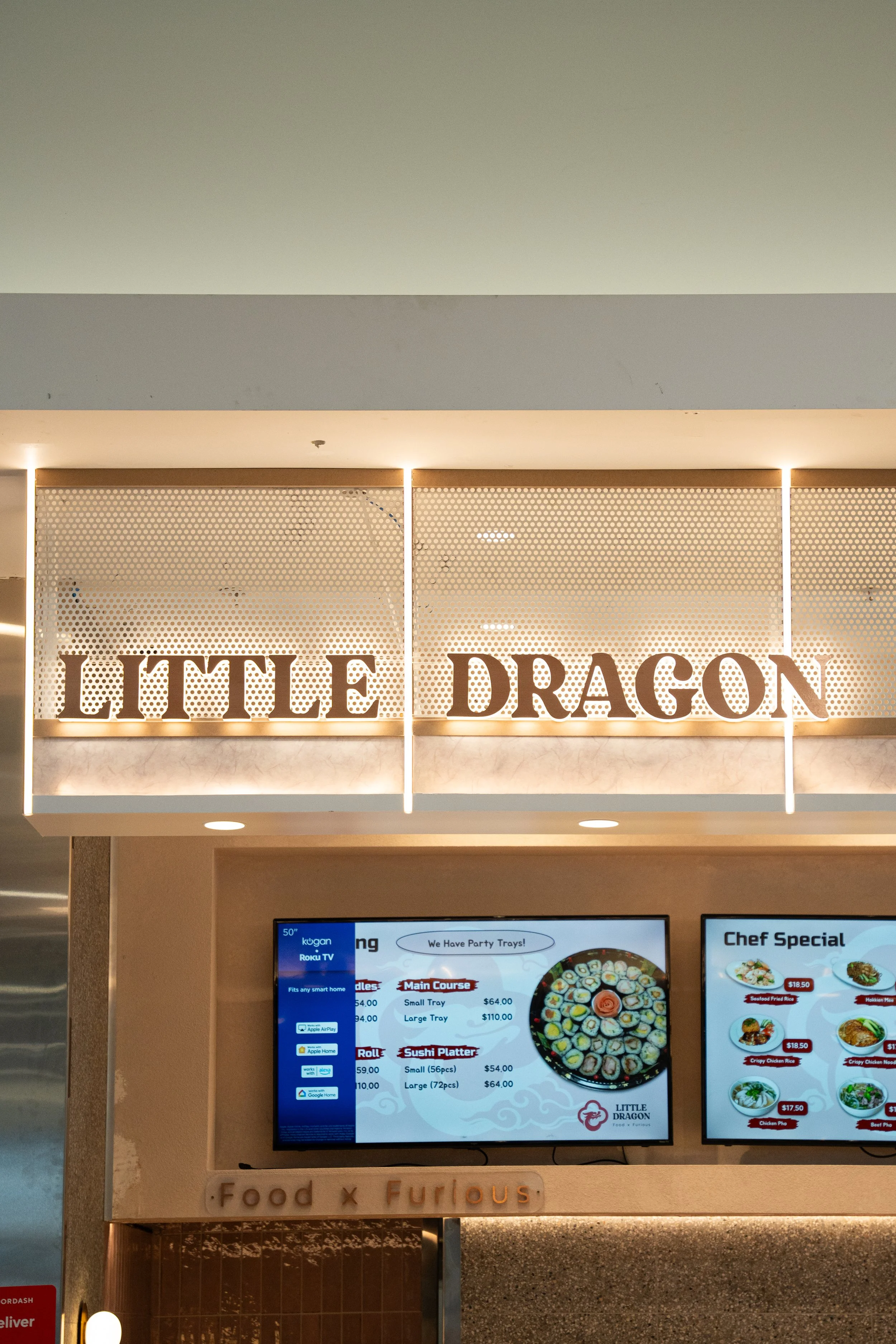 Sign for Little Dragon restaurant with digital menu screens below.