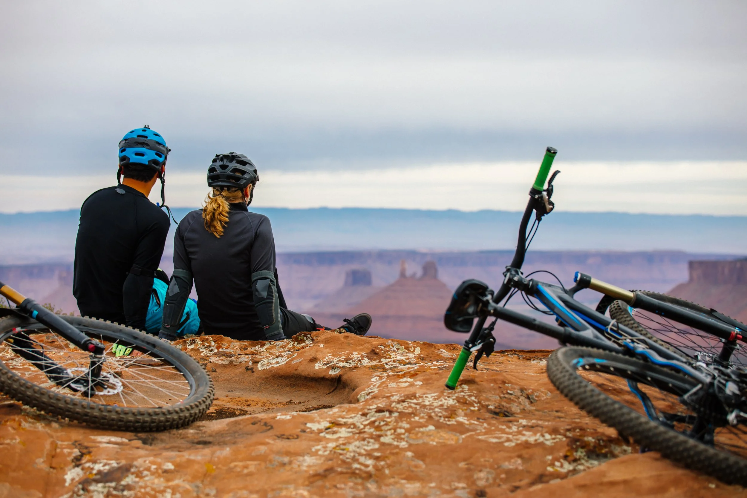 Mountain bike couple looking over mesa and mountains, Santa Fe, New Mexico, guided rides and tours