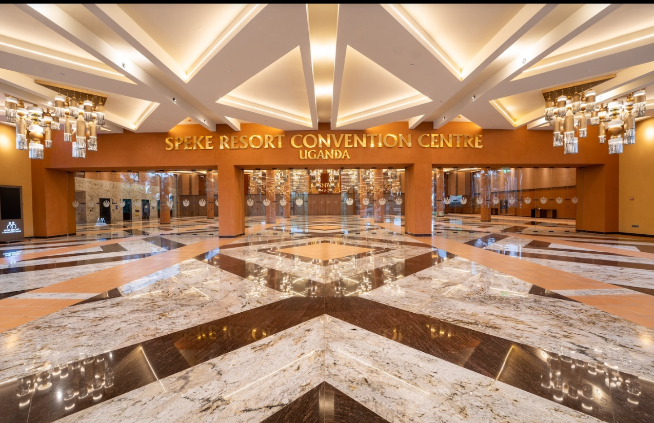 Lobby of Speke Resort Convention Centre Uganda with marble flooring, elegant lighting fixtures, and the center logo.