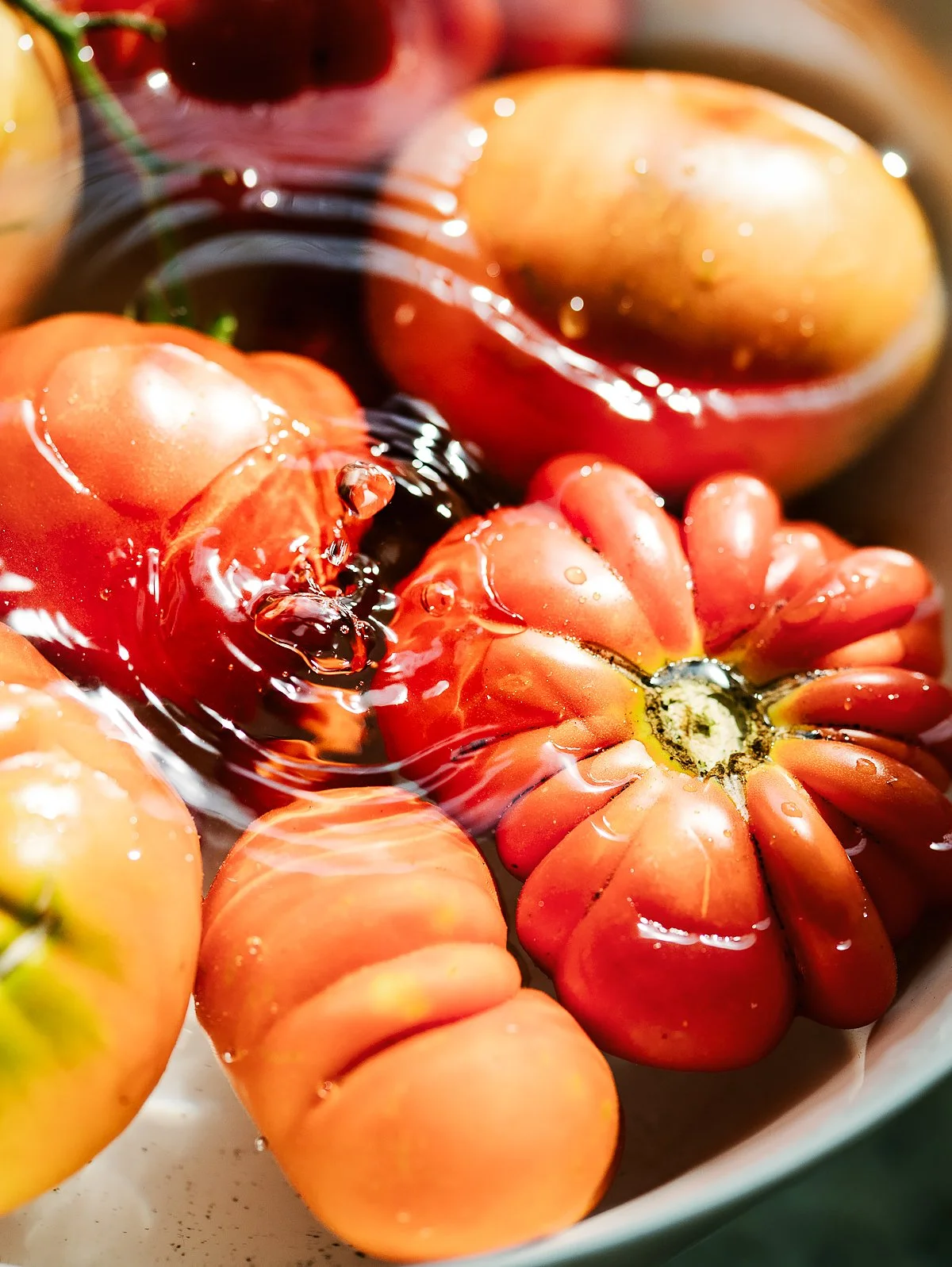 Close-up of ripe tomatoes submerged in water.