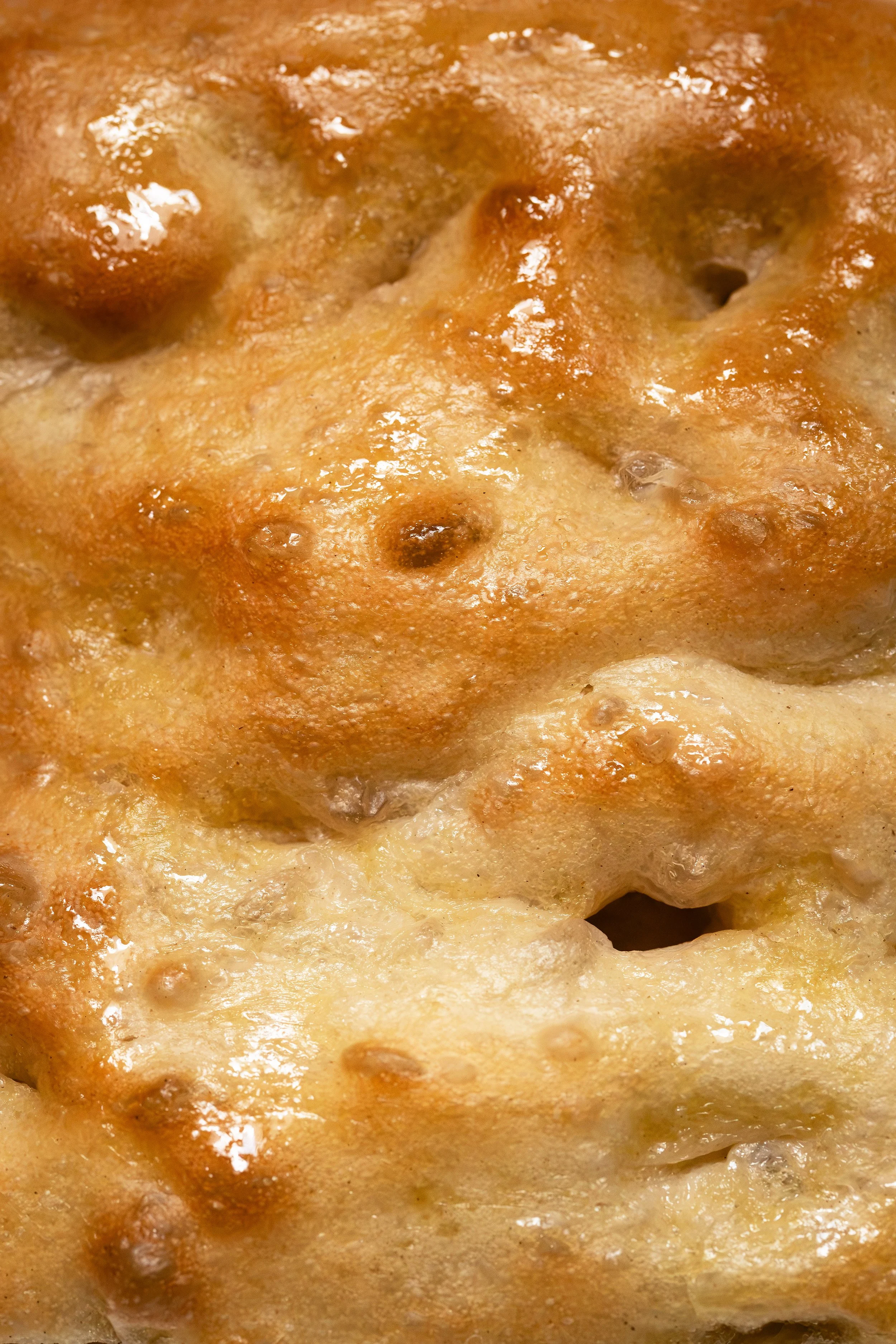Close-up of a freshly baked cheese pizza with golden, bubbly cheese and a crispy crust.