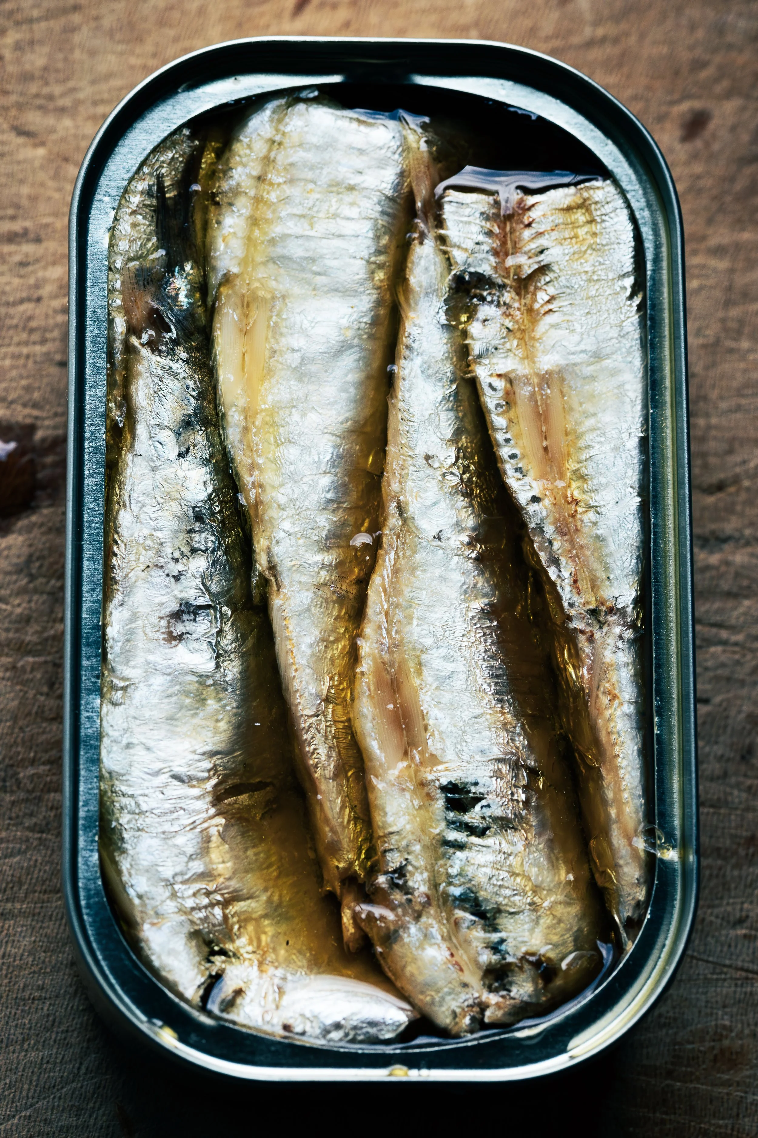 Canned sardines in oil in a silver metal can.