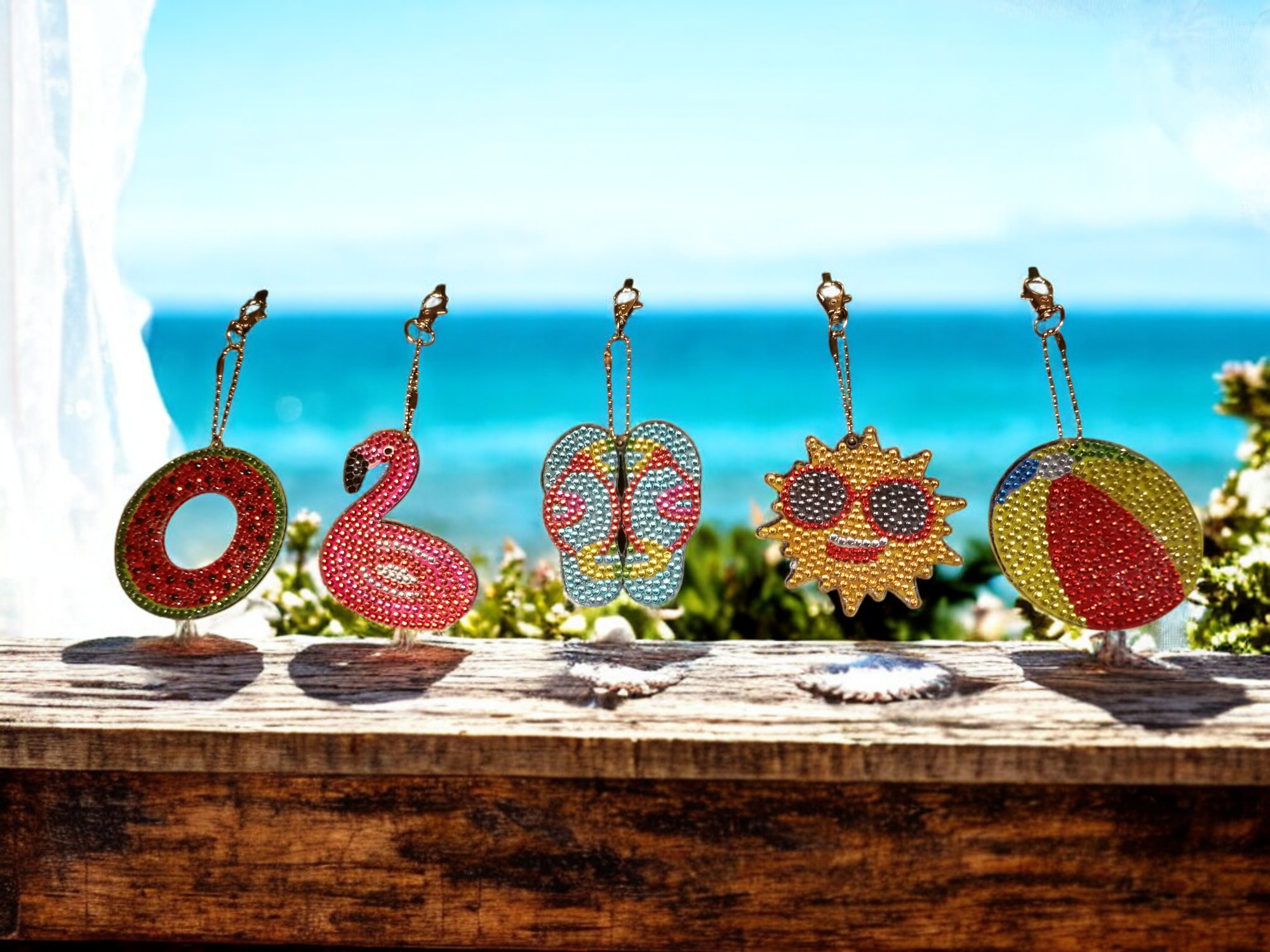 Colorful decorative items spelling out 'LOVE' on a wooden surface with an ocean view background.