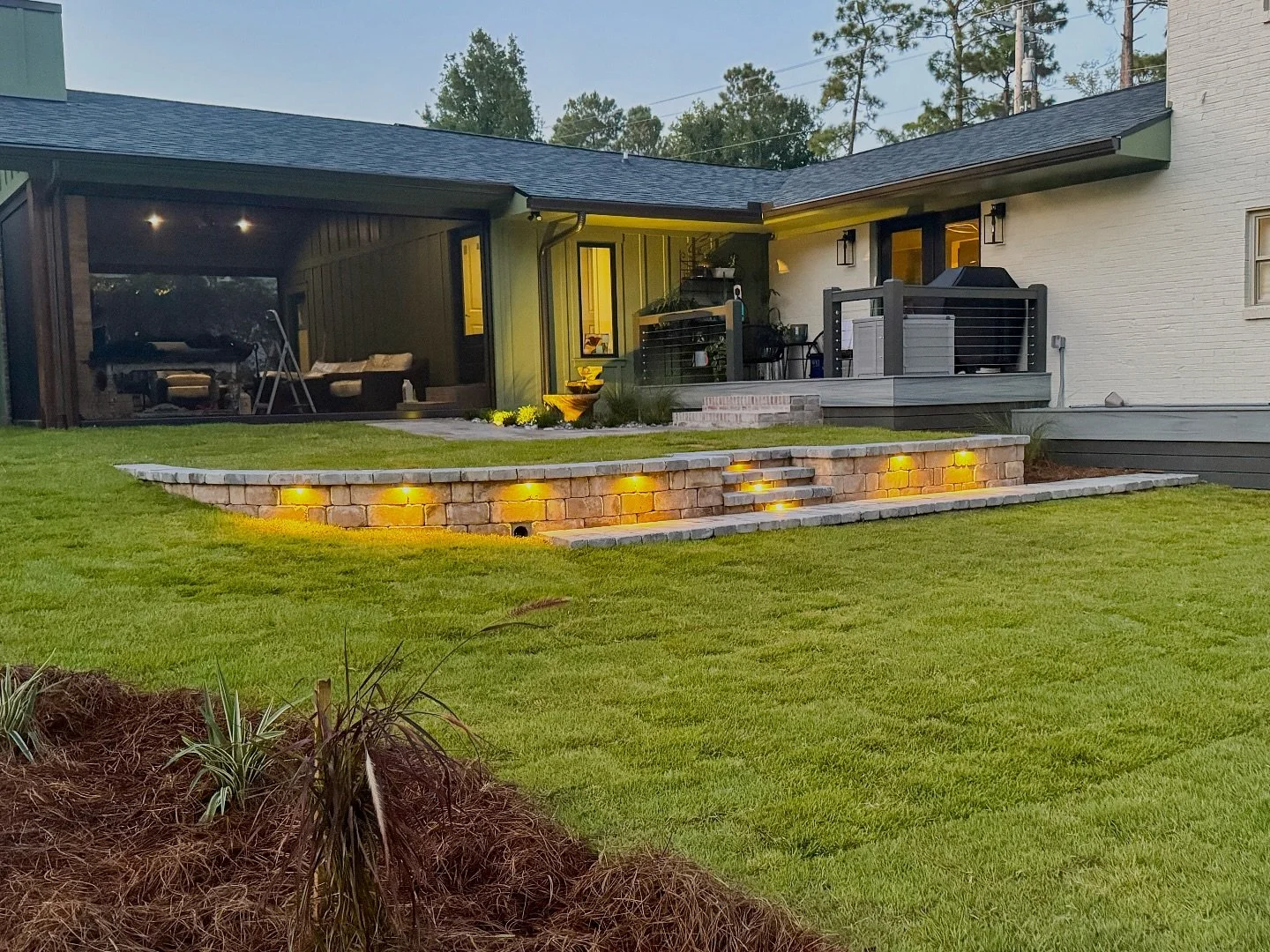 We love seeing client photos of our work in action! Fresh landscaping, custom lighting, and a stunning new retaining wall, the perfect trio for a fall refresh✨🌾