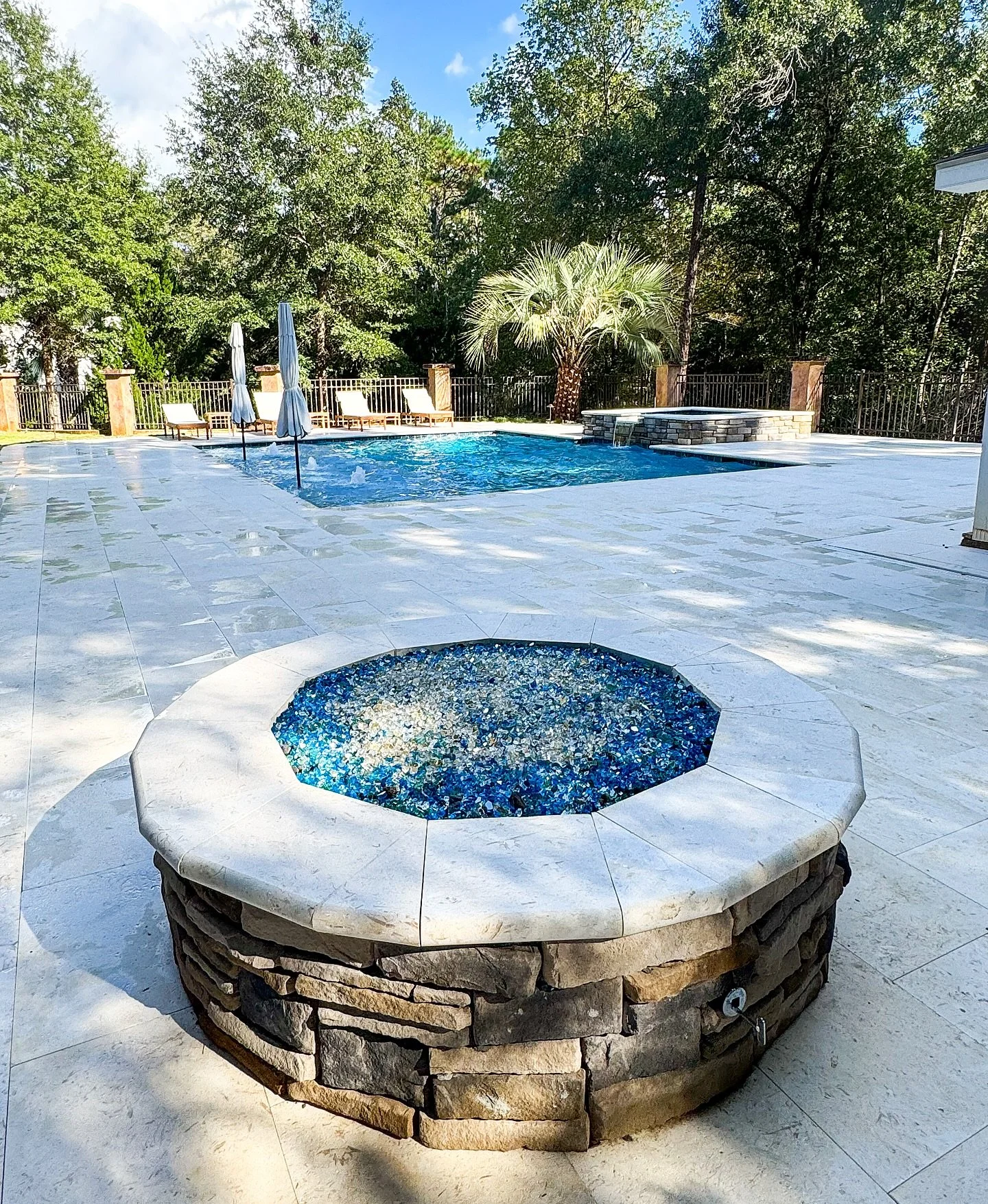 A complete backyard renovation designed for timeless beauty &amp; functional outdoor living! This project features a Shellstone pool deck &amp; coping, Ledgestone spa accent, color-changing landscape lighting, fresh sod &amp; landscaping, and a custo