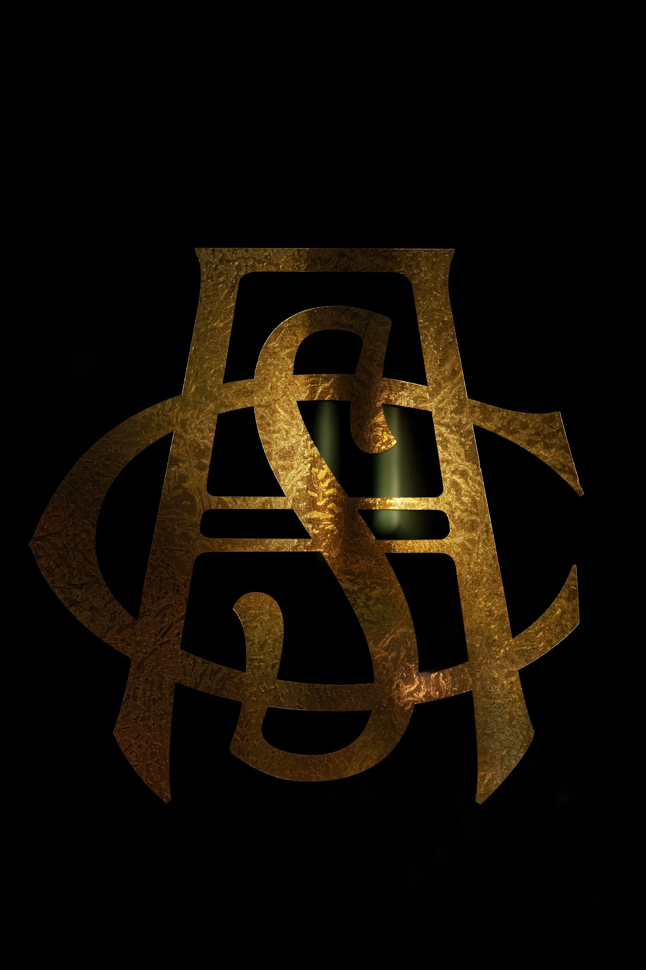 Gold Austin Sports Club monogram displayed against a black background.