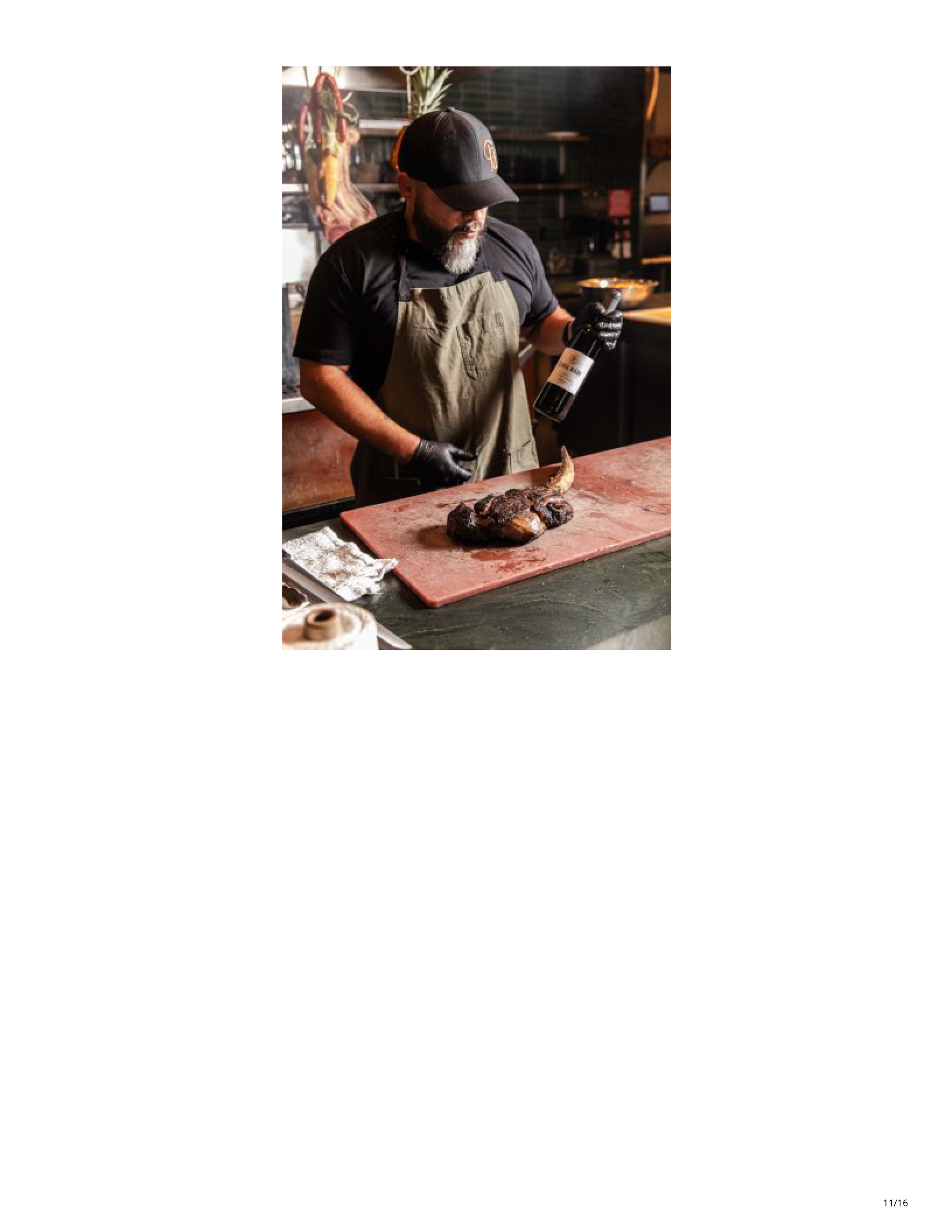 Chef at Filthy Animal finishing a wood-fired tomahawk steak with wine.