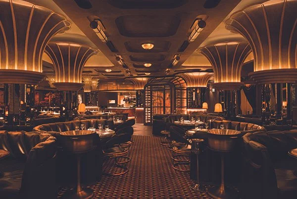 Chef's counter at Cleaverman Steakhouse featuring warm walnut finishes, sculptural detailing, and intimate hospitality design.