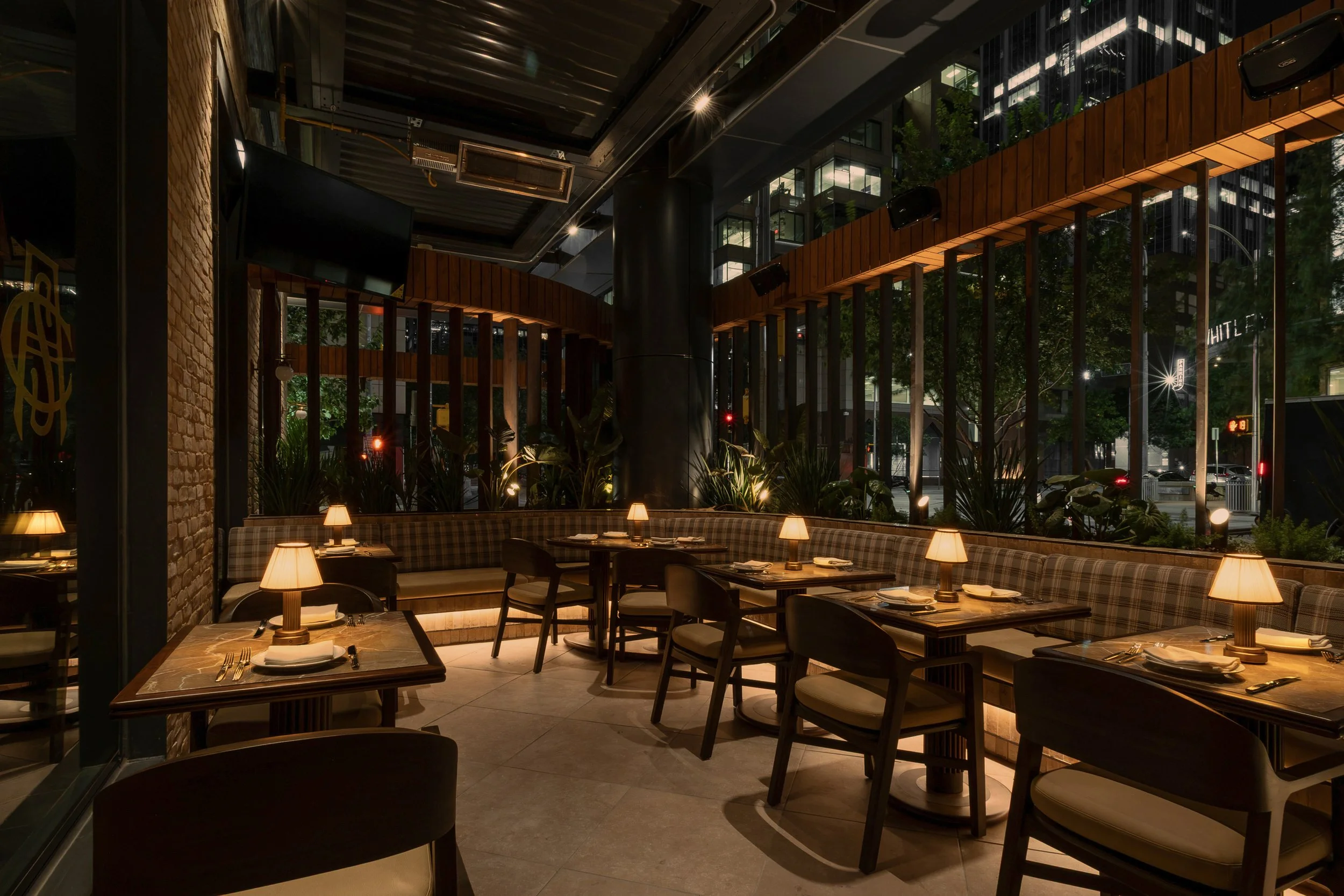 Lush planting and floor-to-ceiling windows surround Austin Sports Club’s light-filled dining area.