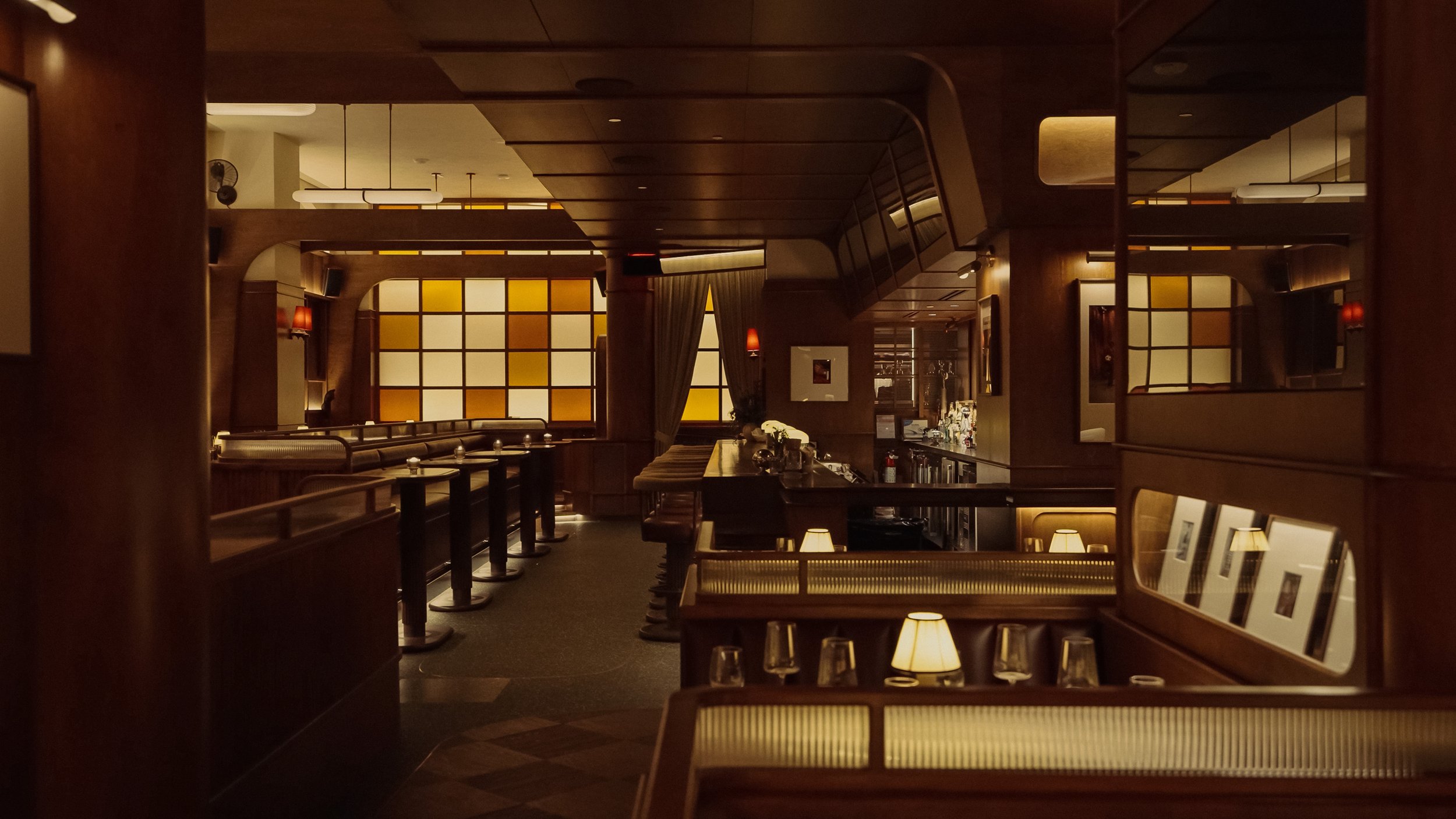 Layered banquettes, shaded table lamps and warm amber glazing create a series of intimate seating zones throughout Austin Sports Club.