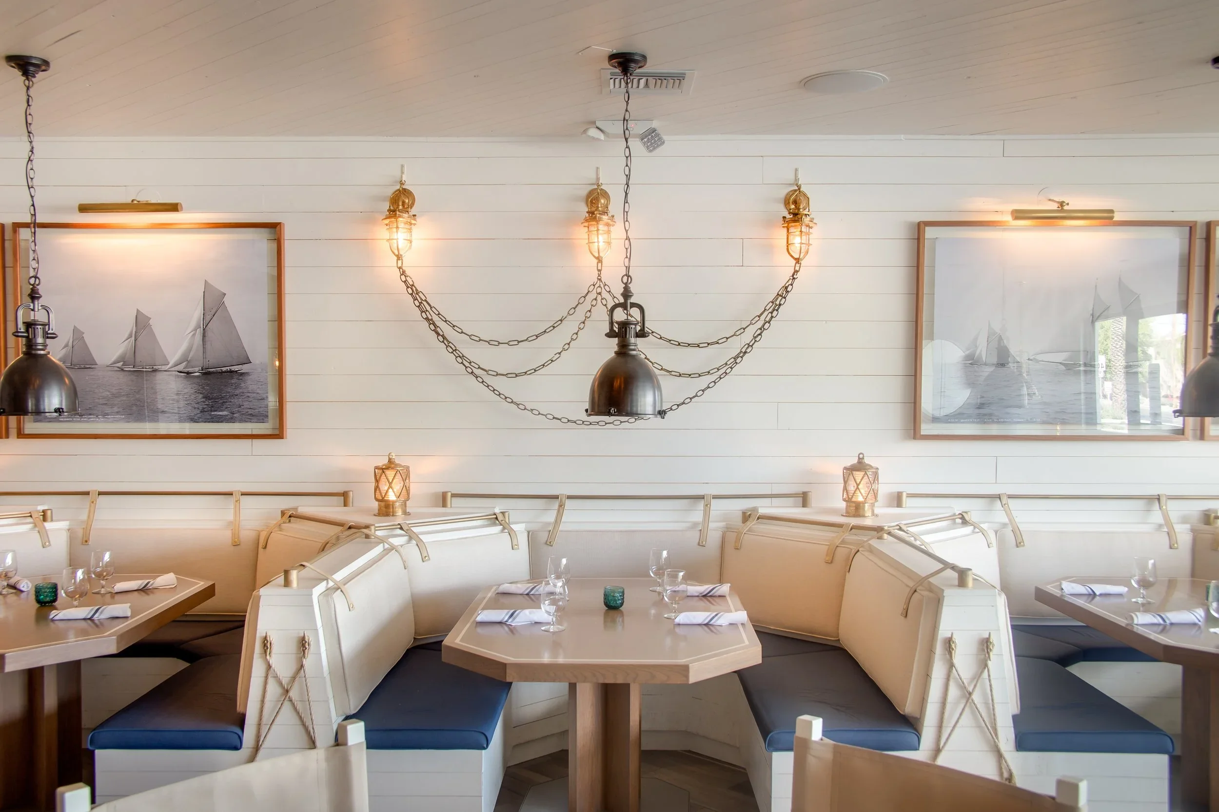 Nautical-inspired interior of The Yacht Club in Phoenix’s Arcadia neighborhood, designed by Peter Bowden with whitewashed wood, porthole windows and collected maritime pieces.