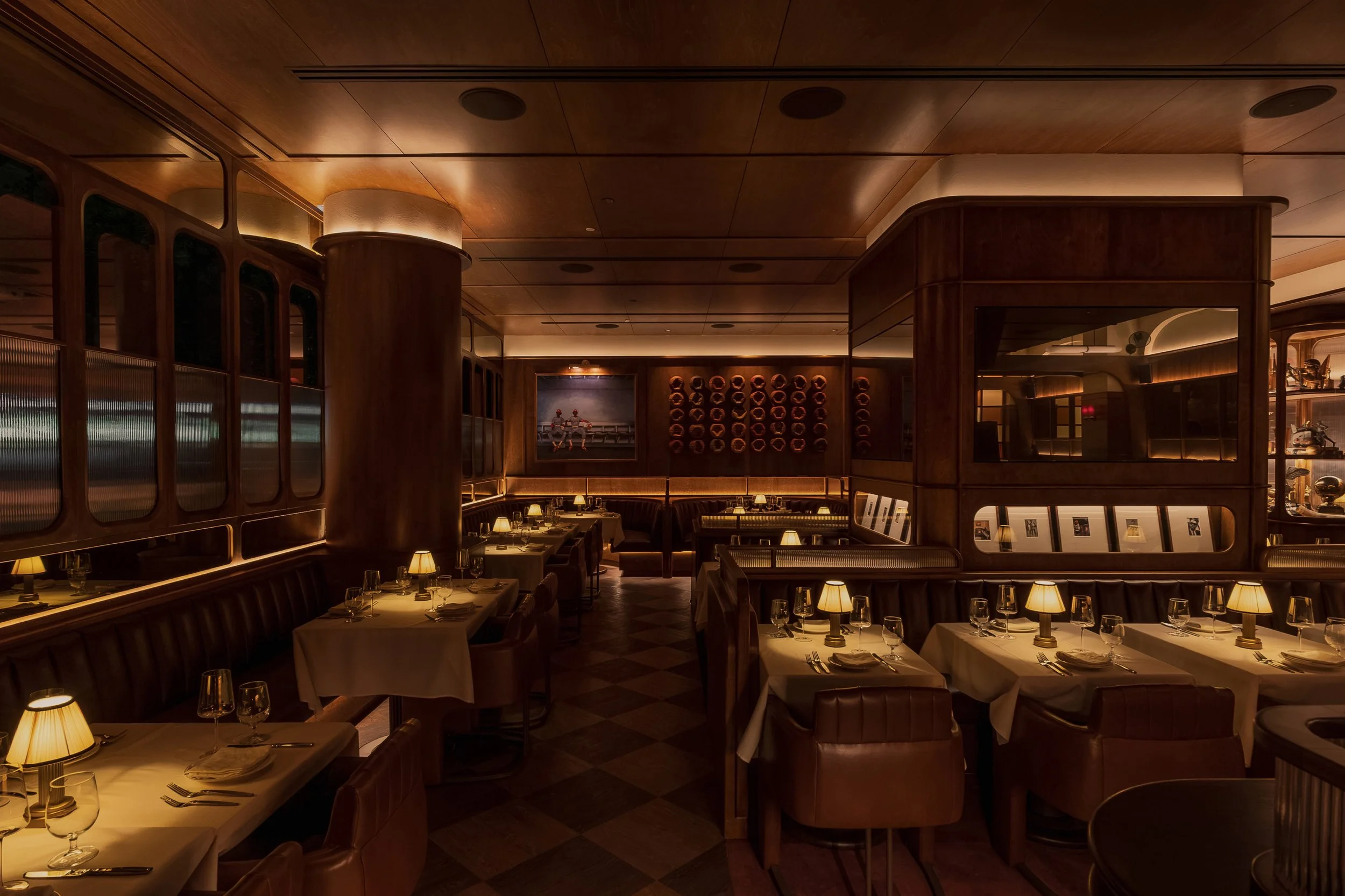 Wide view of Austin Sports Club’s dining room with marble-topped tables, tailored seating and a dramatic wall-mounted basketball collection.