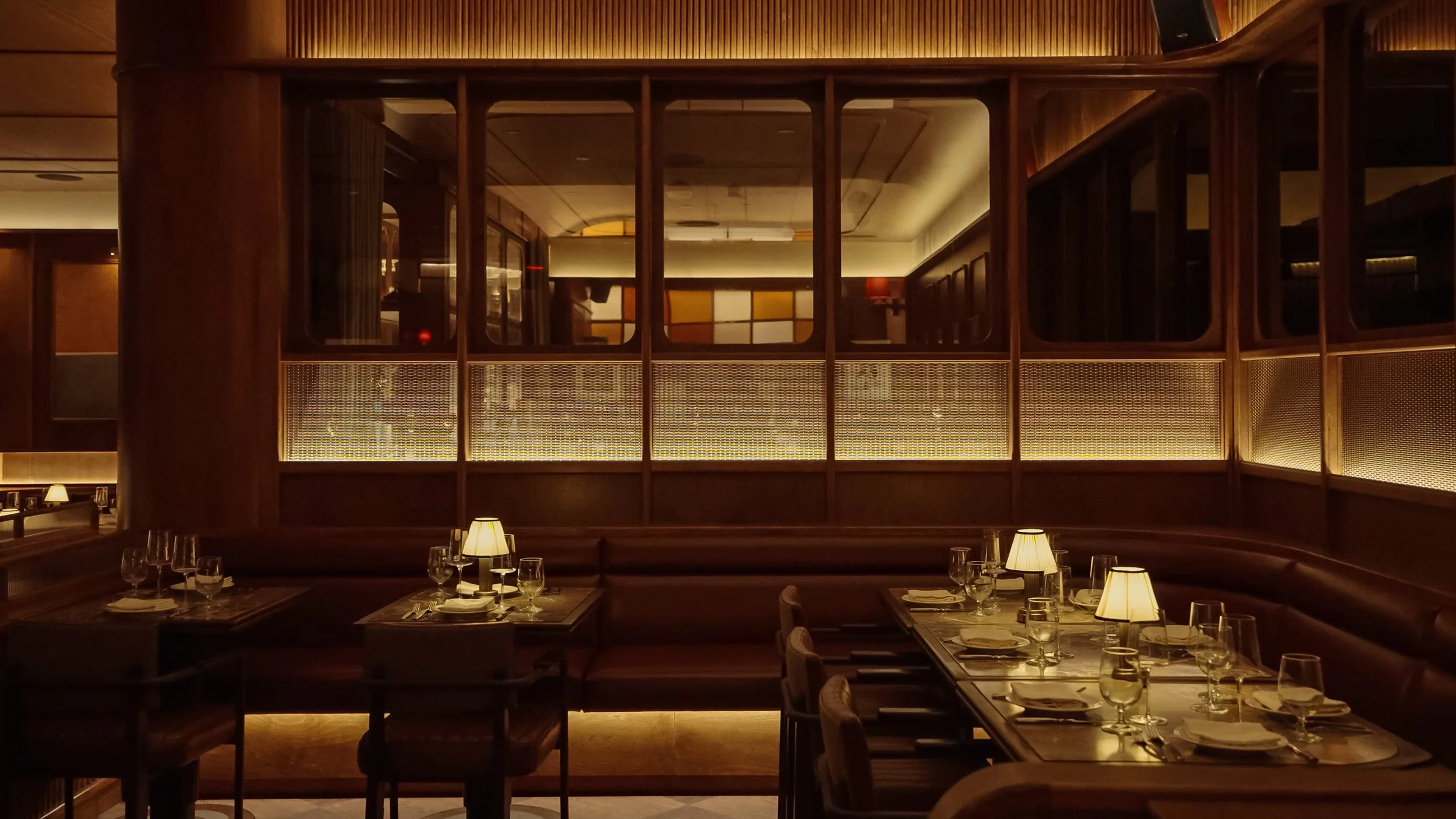 An intimate booth at Austin Sports Club features leather seating, shaded table lamps and decorative glass-and-metal screens.