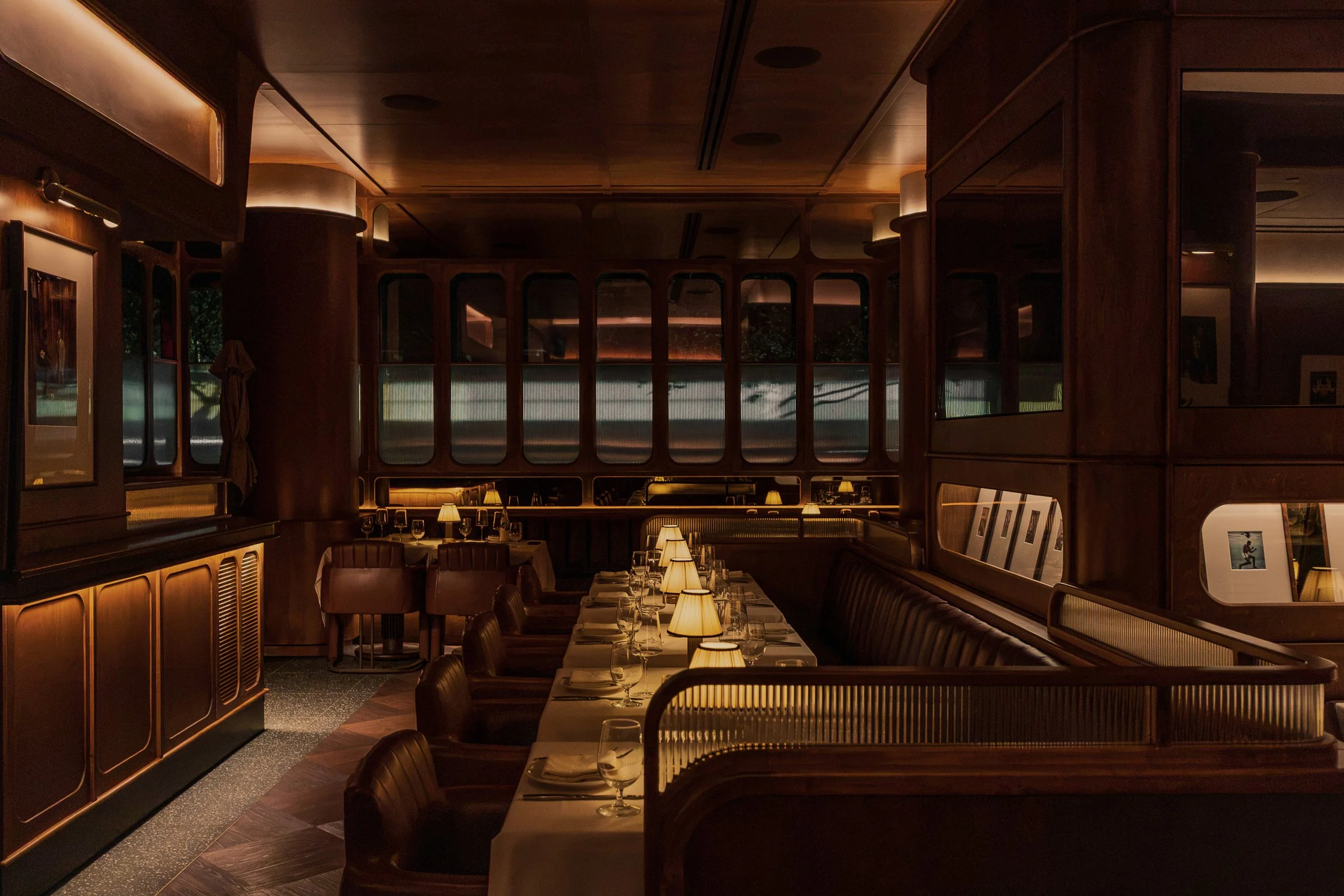 Austin Sports Club’s dining room pairs tailored seating and crisp table settings with warm wood paneling and curated sports displays.