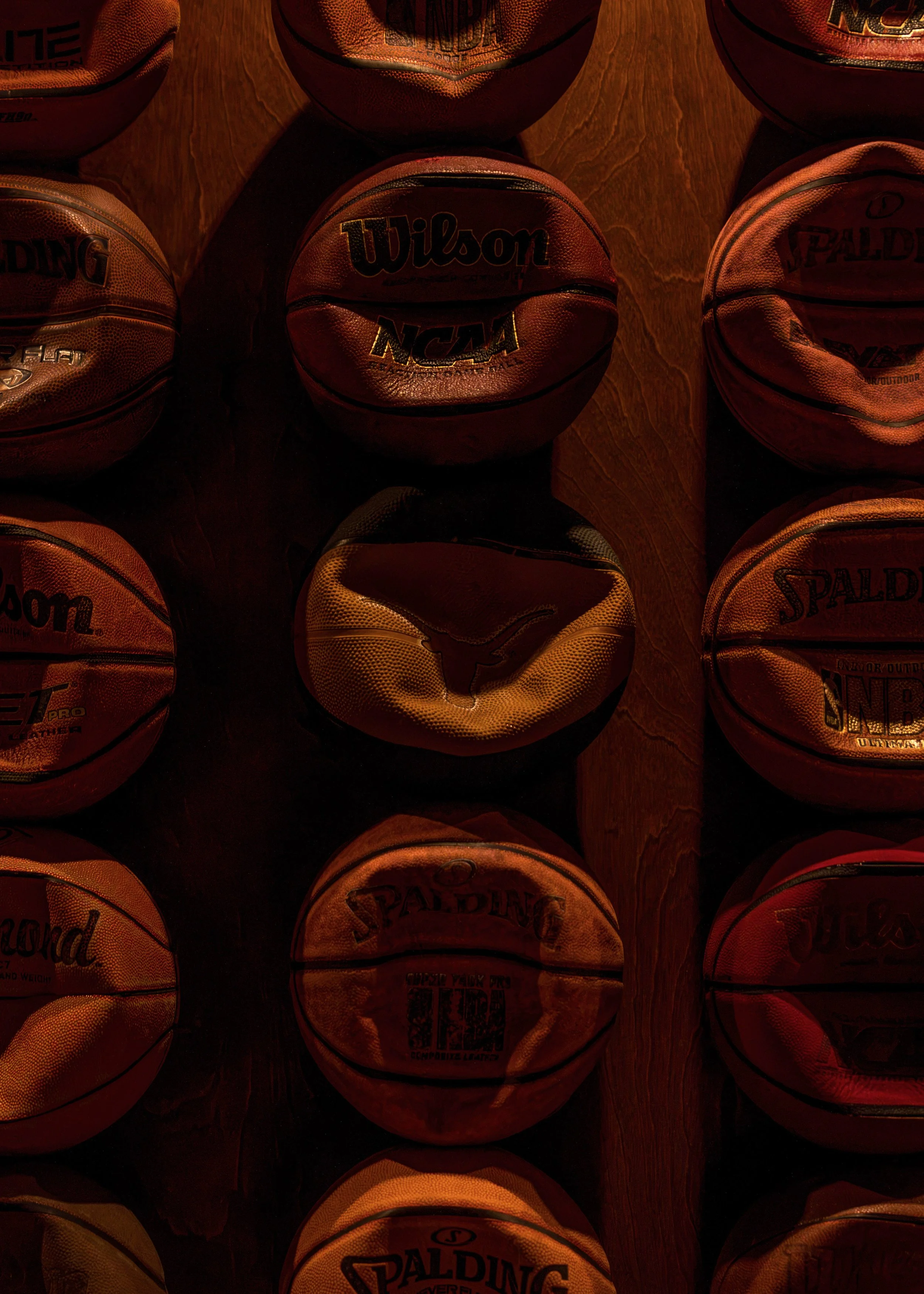 Close-up of vintage basketballs arranged as a textured art installation within Austin Sports Club.
