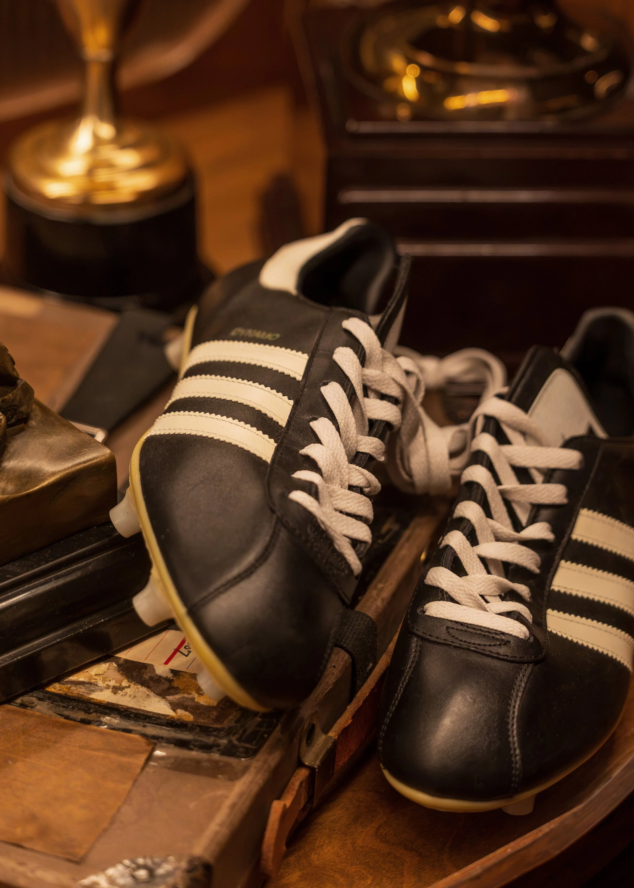 Vintage black-and-white athletic shoes are displayed as part of Austin Sports Club’s curated collection of sports memorabilia.